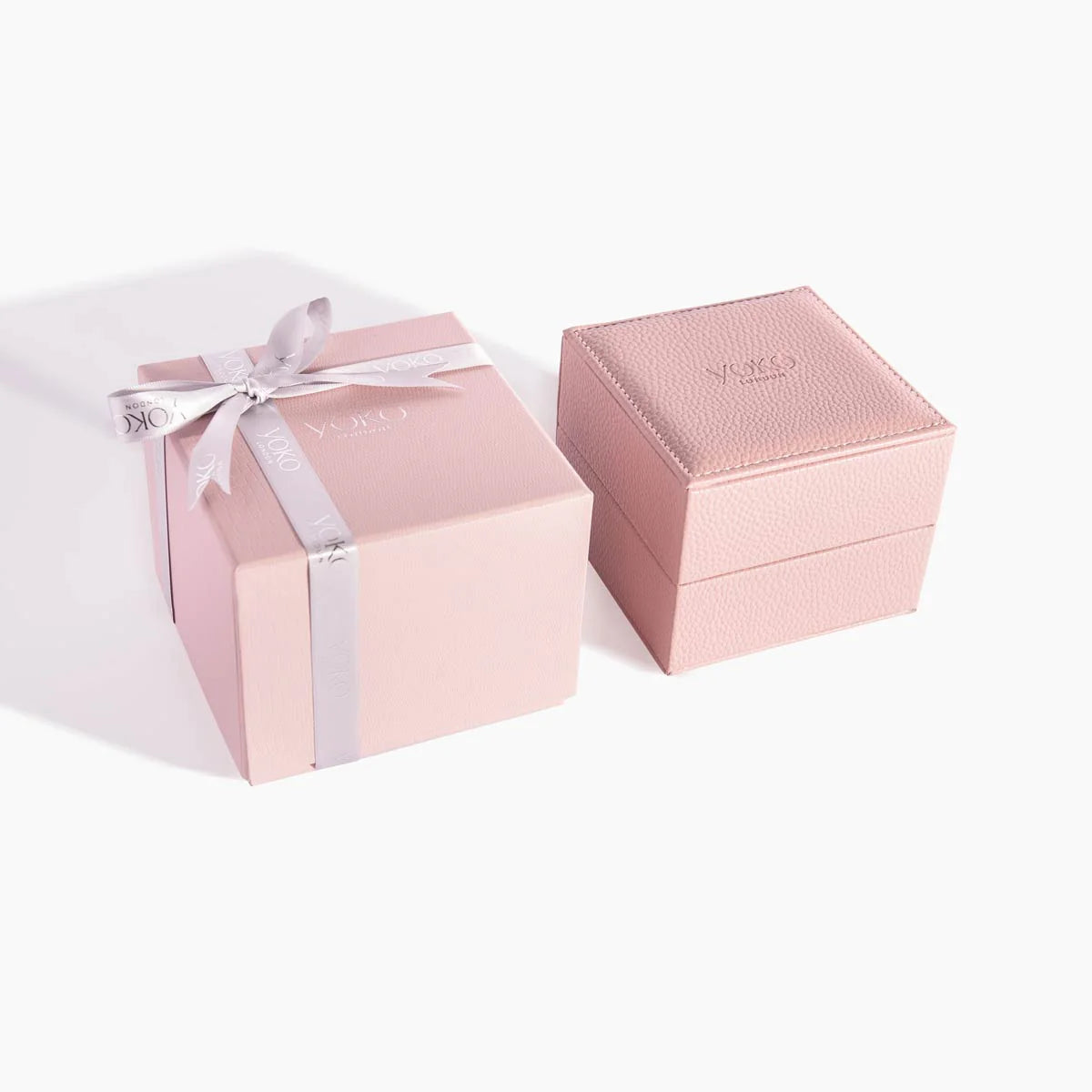 Two pink jewelry boxes with a pink ribbon on a white background