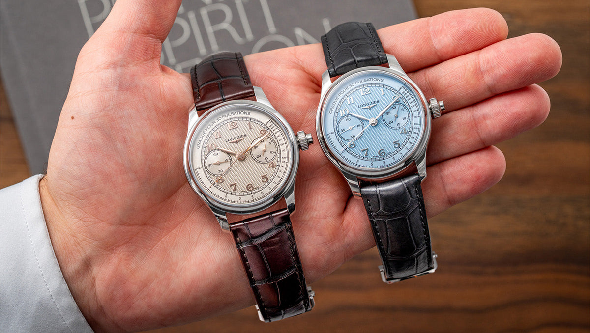 Two Longines Master Collection Chrono Monopusher watches with ivory and blue dials held side by side