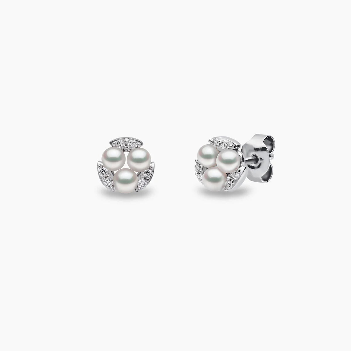 White gold triple pearl and diamond stud earrings on grey background, front  and side angle view