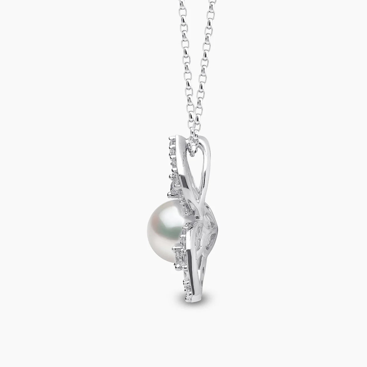 White gold cable chain necklace with pearl pendant surrounded by floral design diamond accents on grey background, side view
