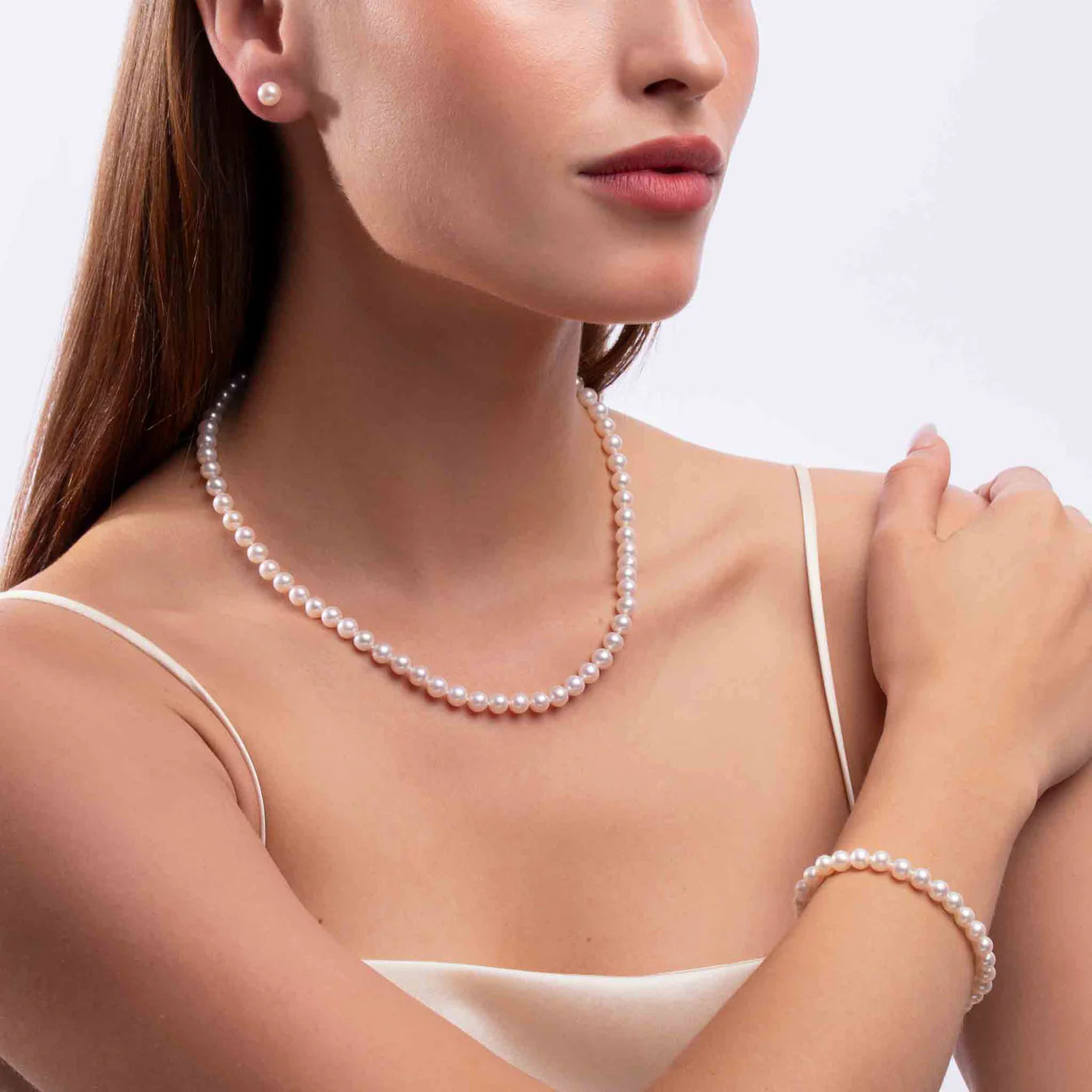 Woman wearing white gold pearl necklace, and bracelet