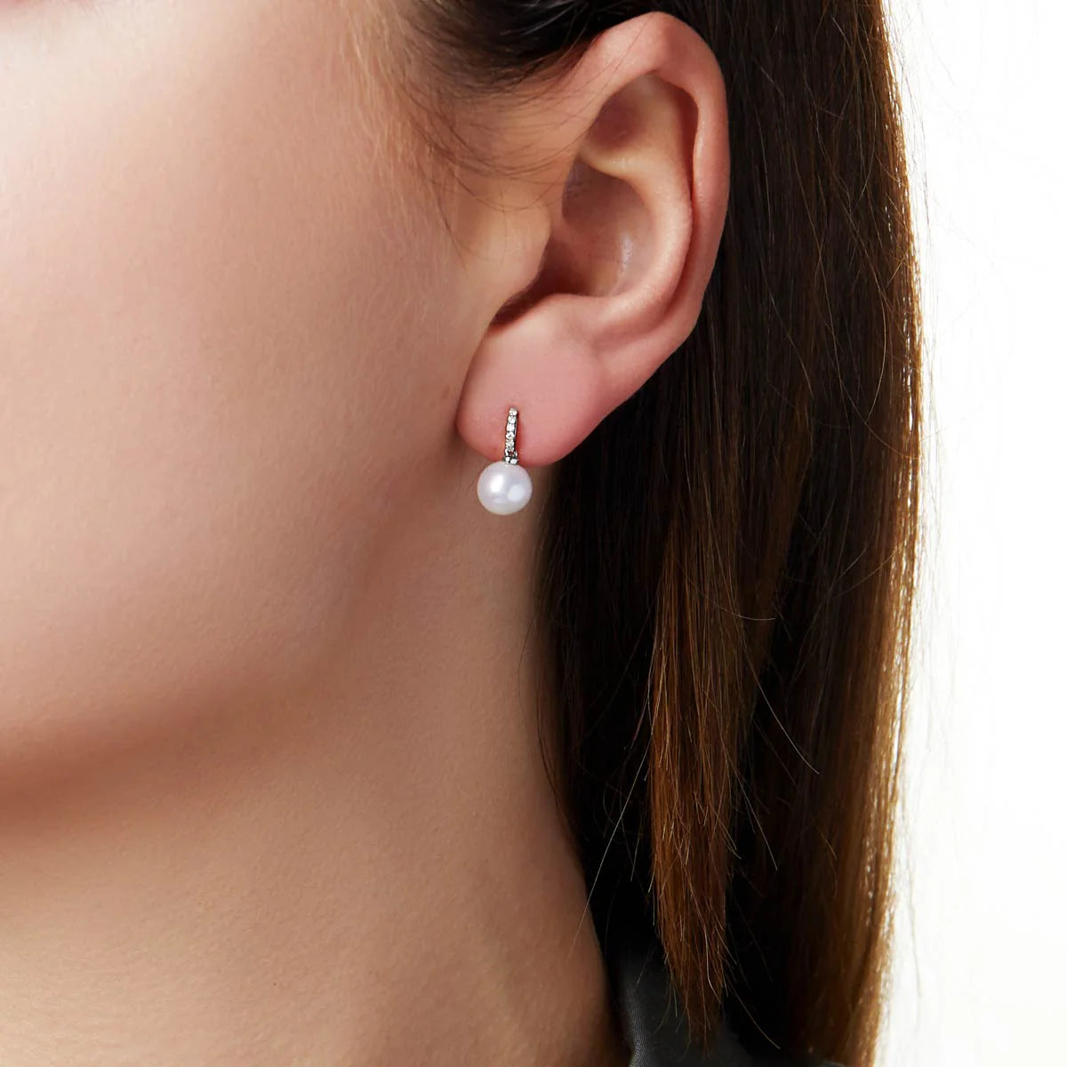 Pearl earring worn by a person with a neutral background