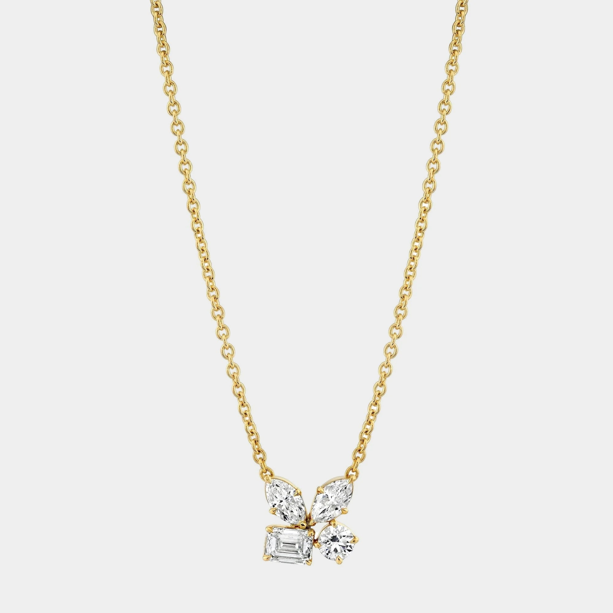 Yellow gold diamond cluster pendant necklace on grey background, front view