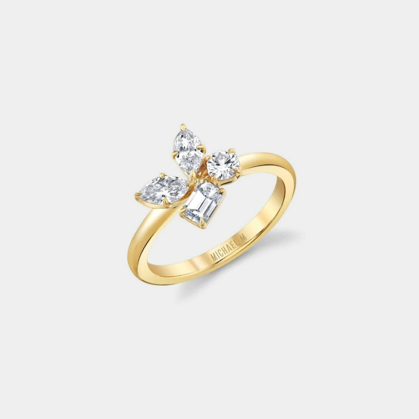 Yellow gold diamond cluster ring on grey background, side angle view