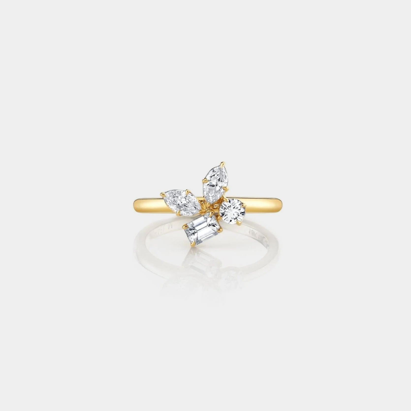 Yellow gold diamond cluster ring on grey background, front angle view
