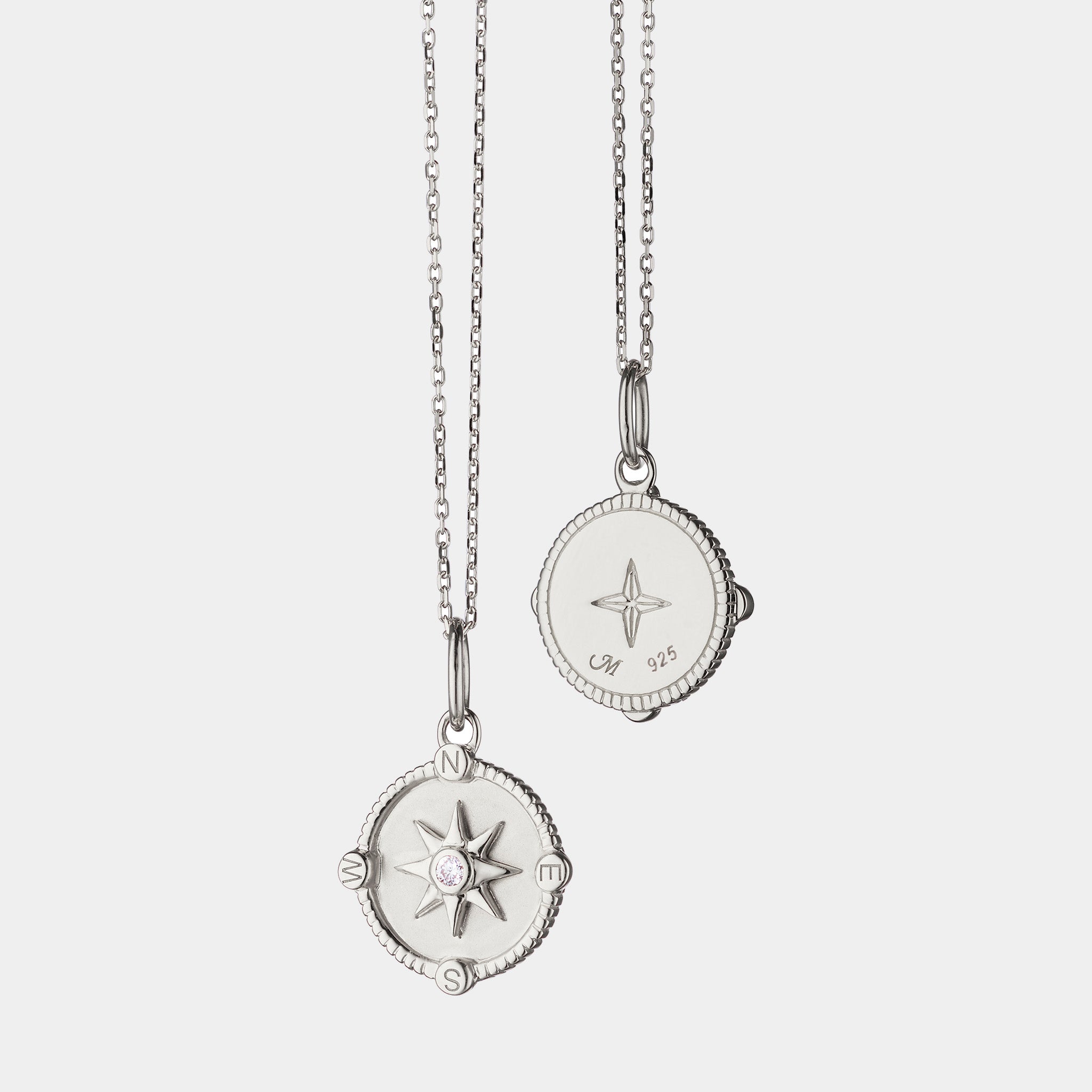 Sterling silver compass pendant necklace on grey background, front and back view
