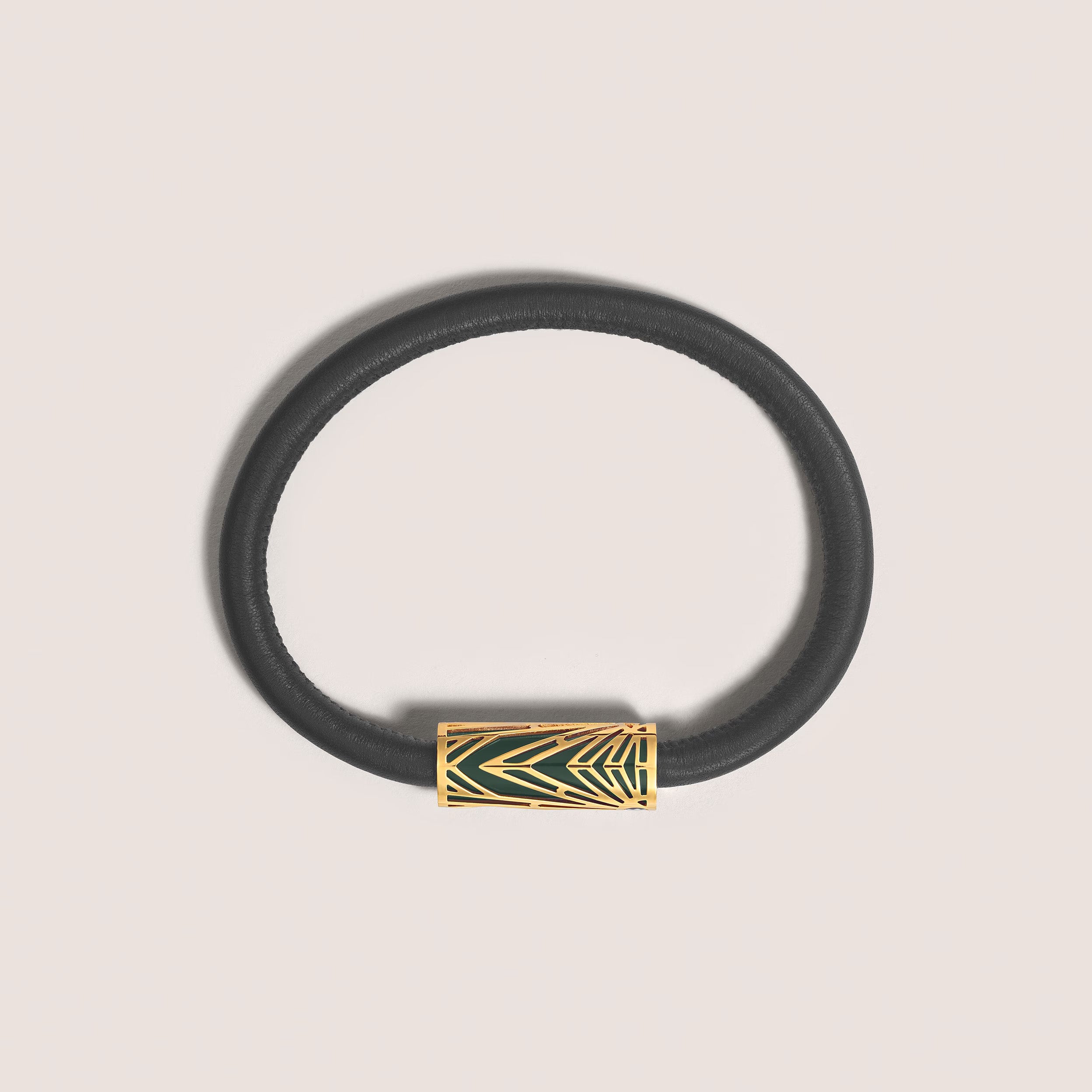 Montblanc Meisterstück Origin black leather bracelet with gold-tone stainless steel clasp featuring green lacquer detailing and Montblanc emblem on a grey background, front view.