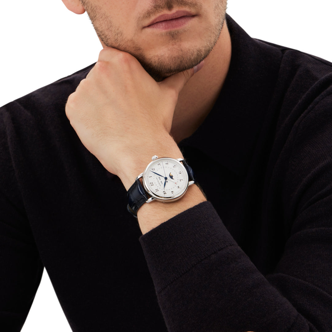 Man wearing a black watch with a white dial on a white background