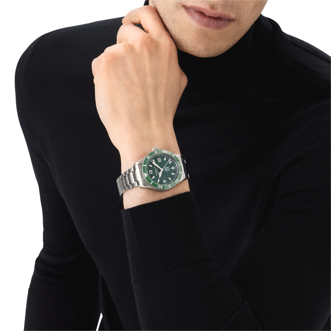 Person wearing a watch with a green face on a white background