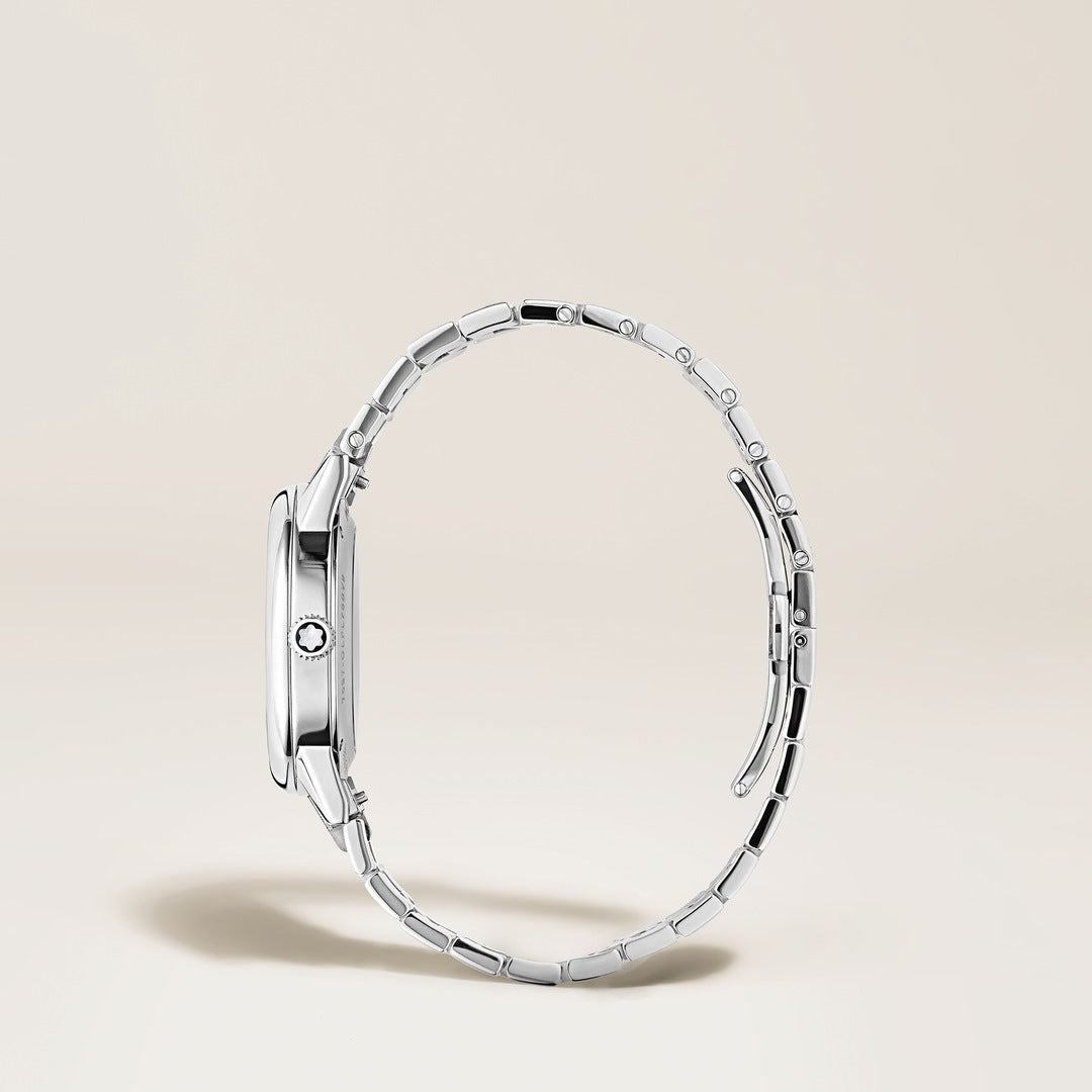 Silver watch with a detailed band on a light beige background