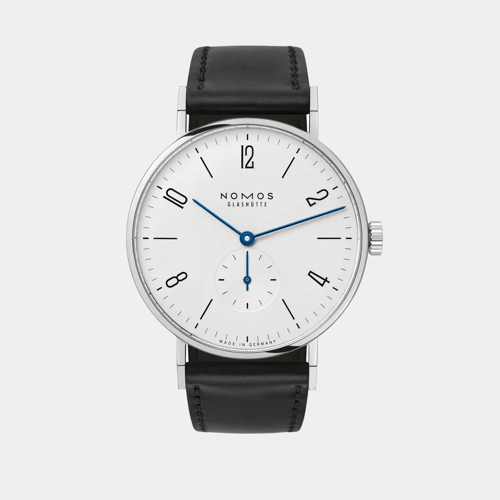 NOMOS Glashütte Tangente 38mm watch with white dial, stainless steel case, and black leather strap on grey background, front angle view.