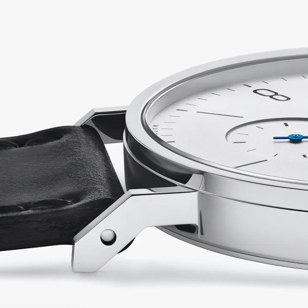 NOMOS Glashütte Tangente 38mm watch with white dial, stainless steel case, and black leather strap on white background, case side view