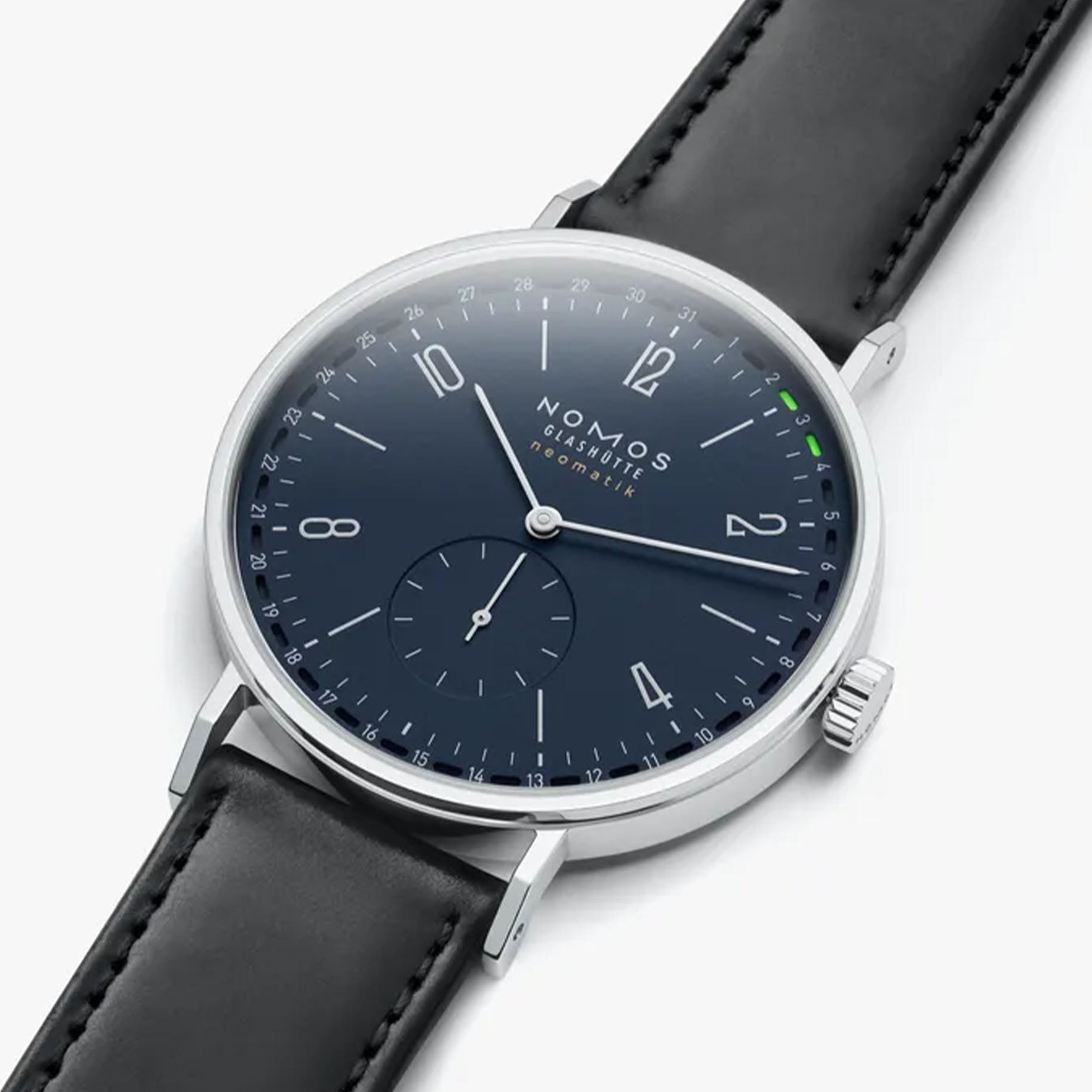 NOMOS Glashütte Tangente Neomatik 41mm watch with midnight blue dial, stainless steel case, and black leather strap on white background, flay lay view.