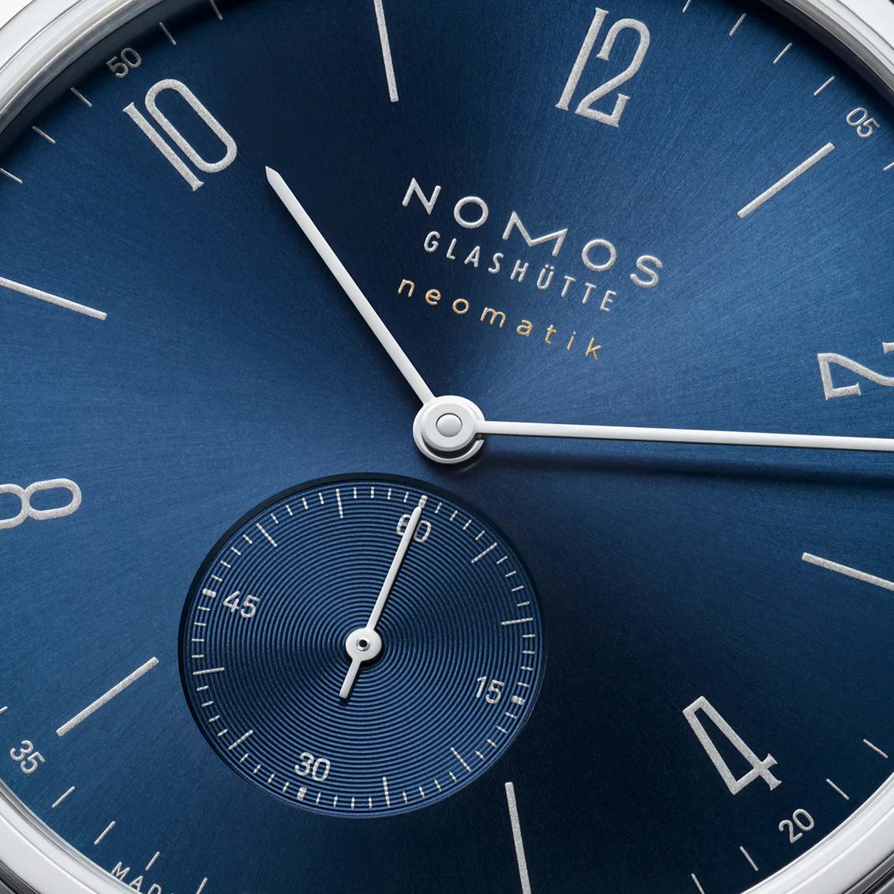 NOMOS Glashütte Tangente Neomatik Blue Gold 39mm automatic watch with blue sunburst dial, stainless steel case, and black leather strap on grey background, small seconds closeup sub dial view.