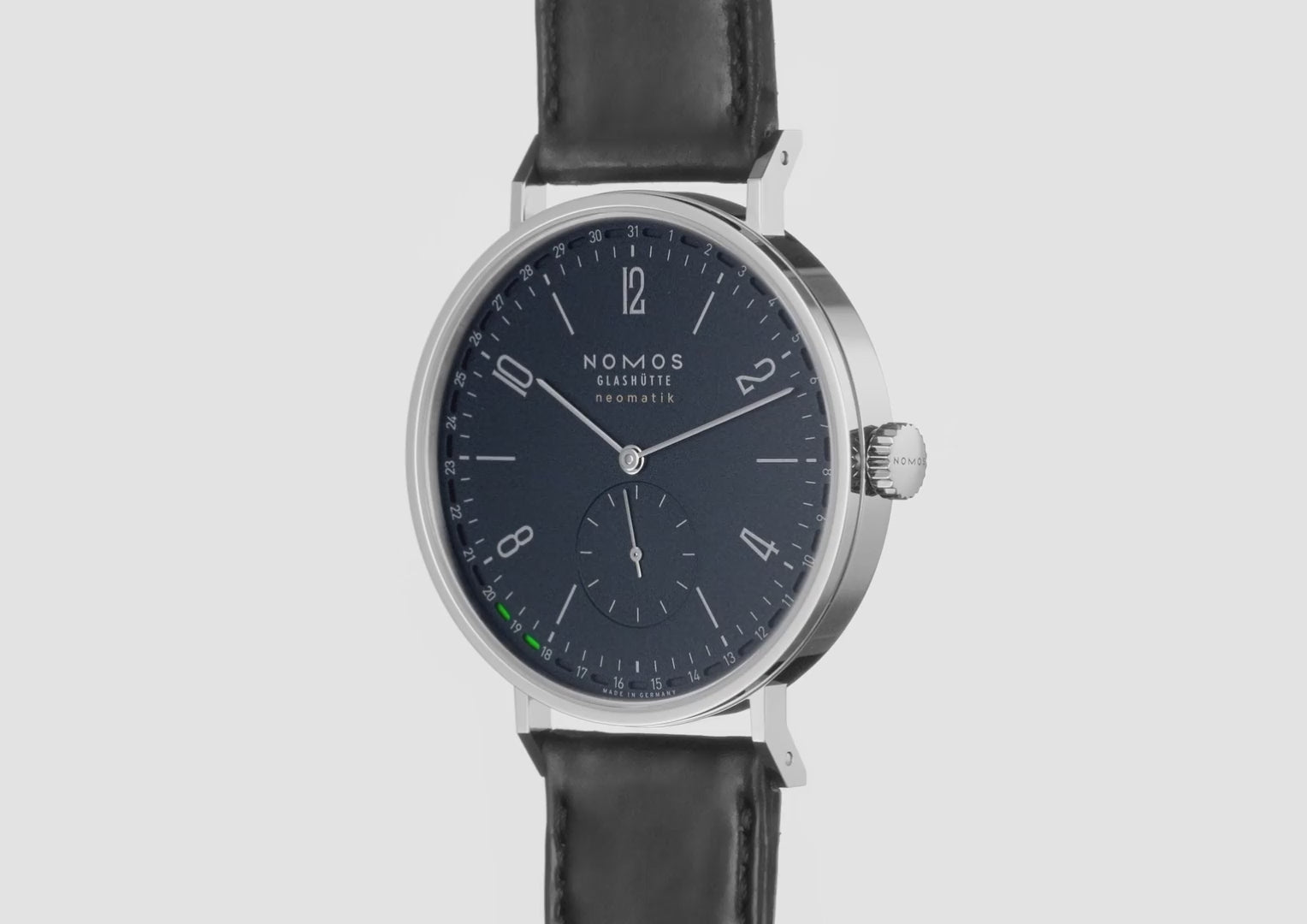 NOMOS Glashütte Tangente Neomatik 41mm watch with midnight blue dial, stainless steel case, and black leather strap on white background, 360 spin