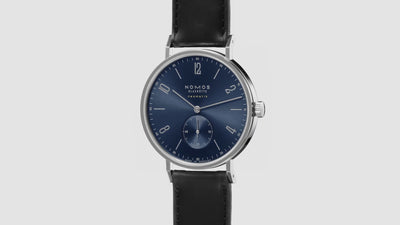 NOMOS Glashütte Tangente Neomatik Blue Gold 39mm automatic watch with blue sunburst dial, stainless steel case, and black leather strap on grey background, 360 spin.