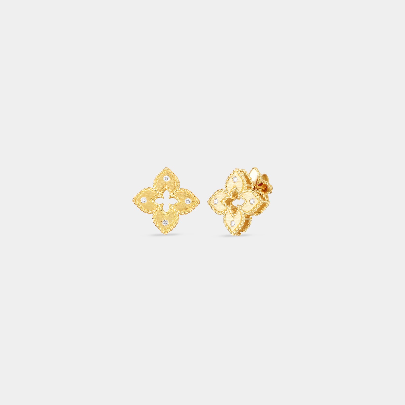 Yellow gold and diamond flower stud earrings on gray background.