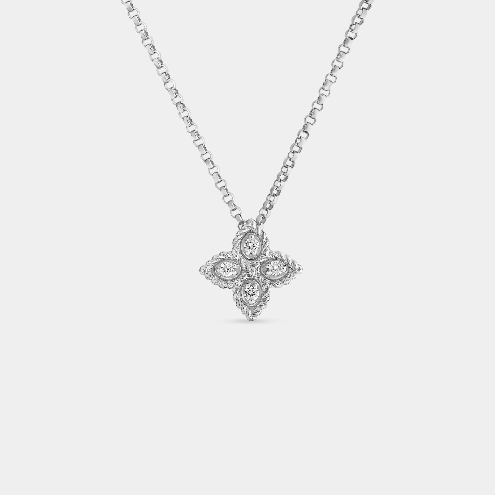 White gold flower shaped diamond pendant on gray background