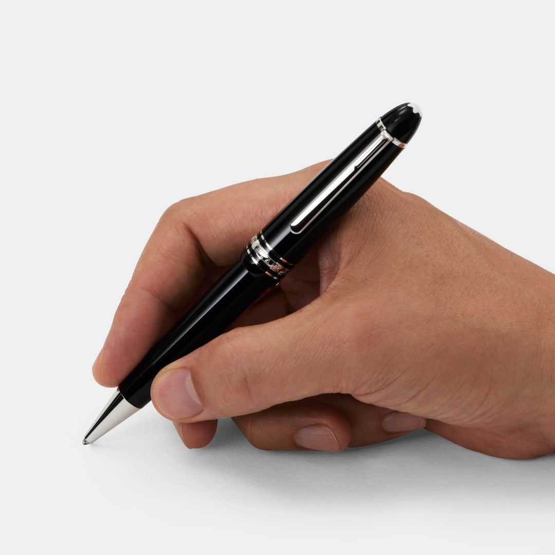 Hand holding a black montblanc pen on a white background