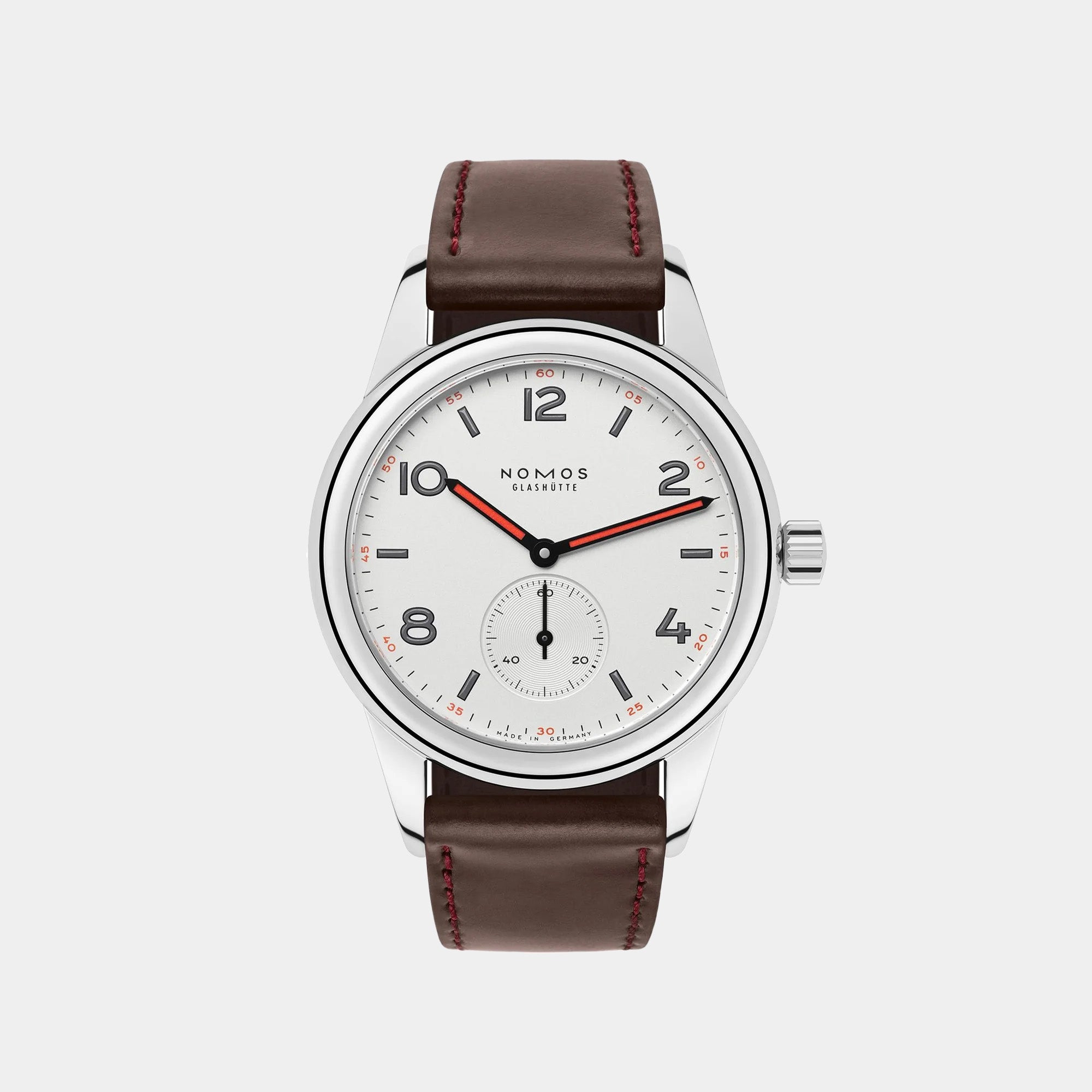 NOMOS Glashütte Club 36mm watch with white silver-plated dial, black and red hands, and brown Horween leather strap on white background, front angle view.