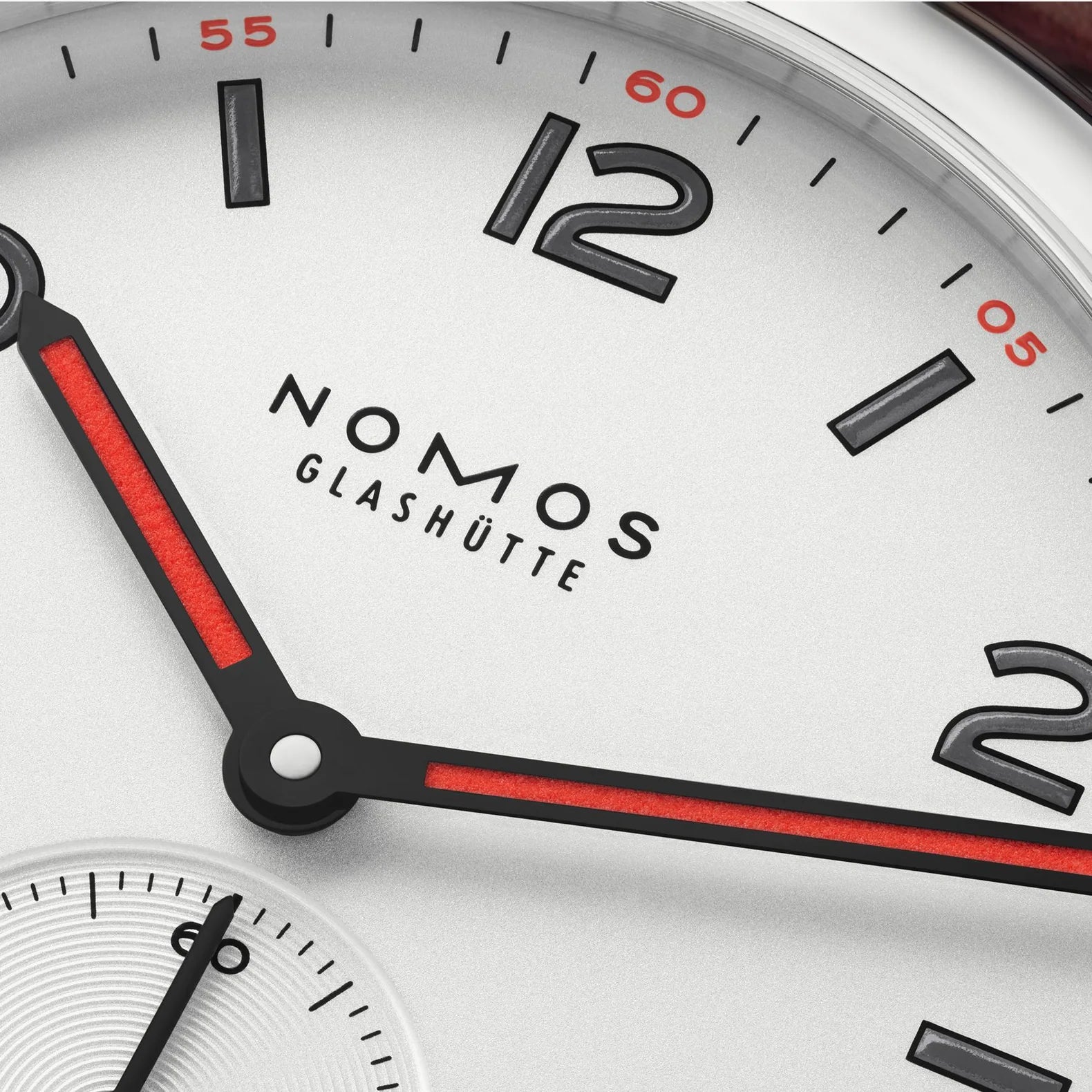 NOMOS Glashütte Club 36mm watch with white silver-plated dial, black and red hands, dial closeup