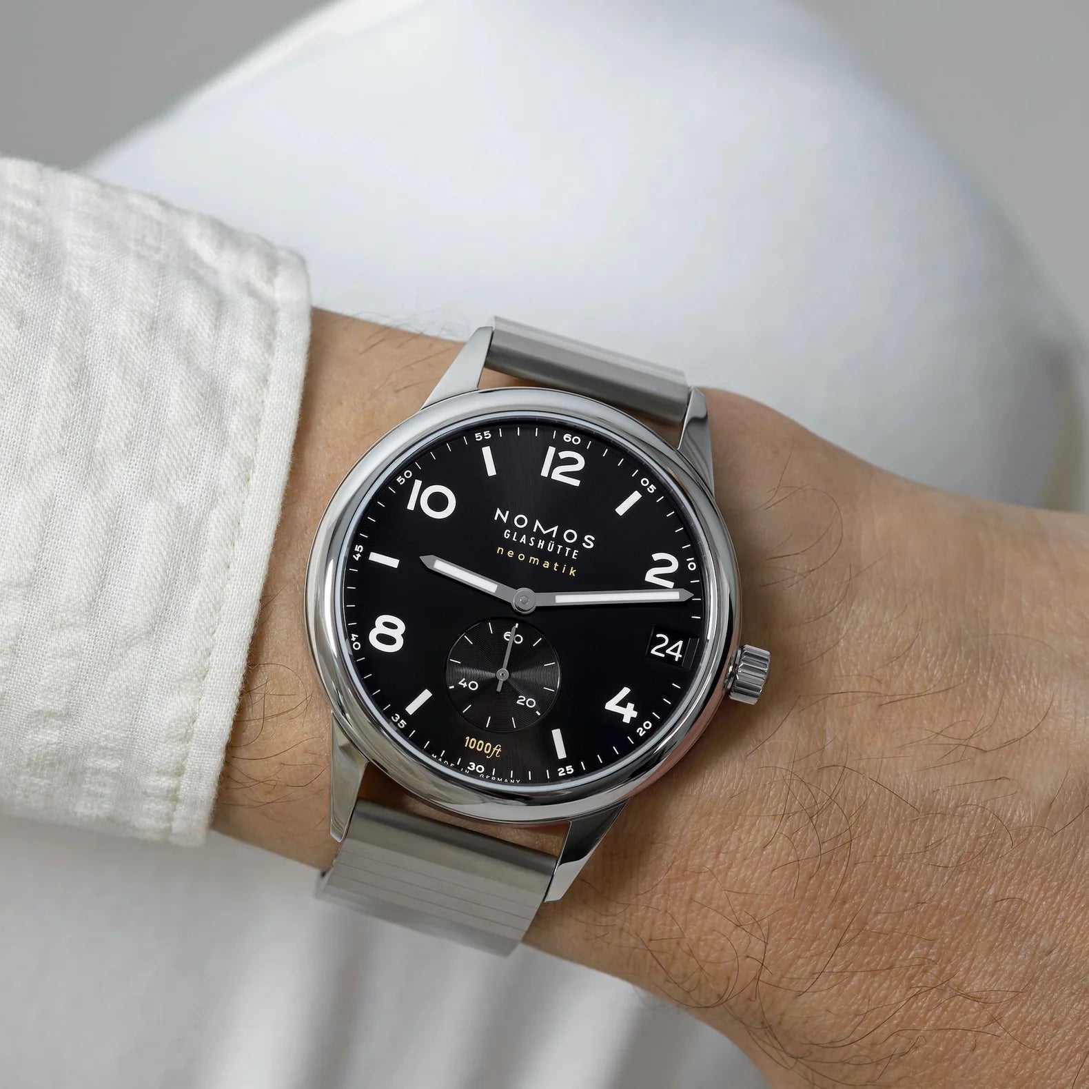 Nomos watch on a wrist with a neutral background