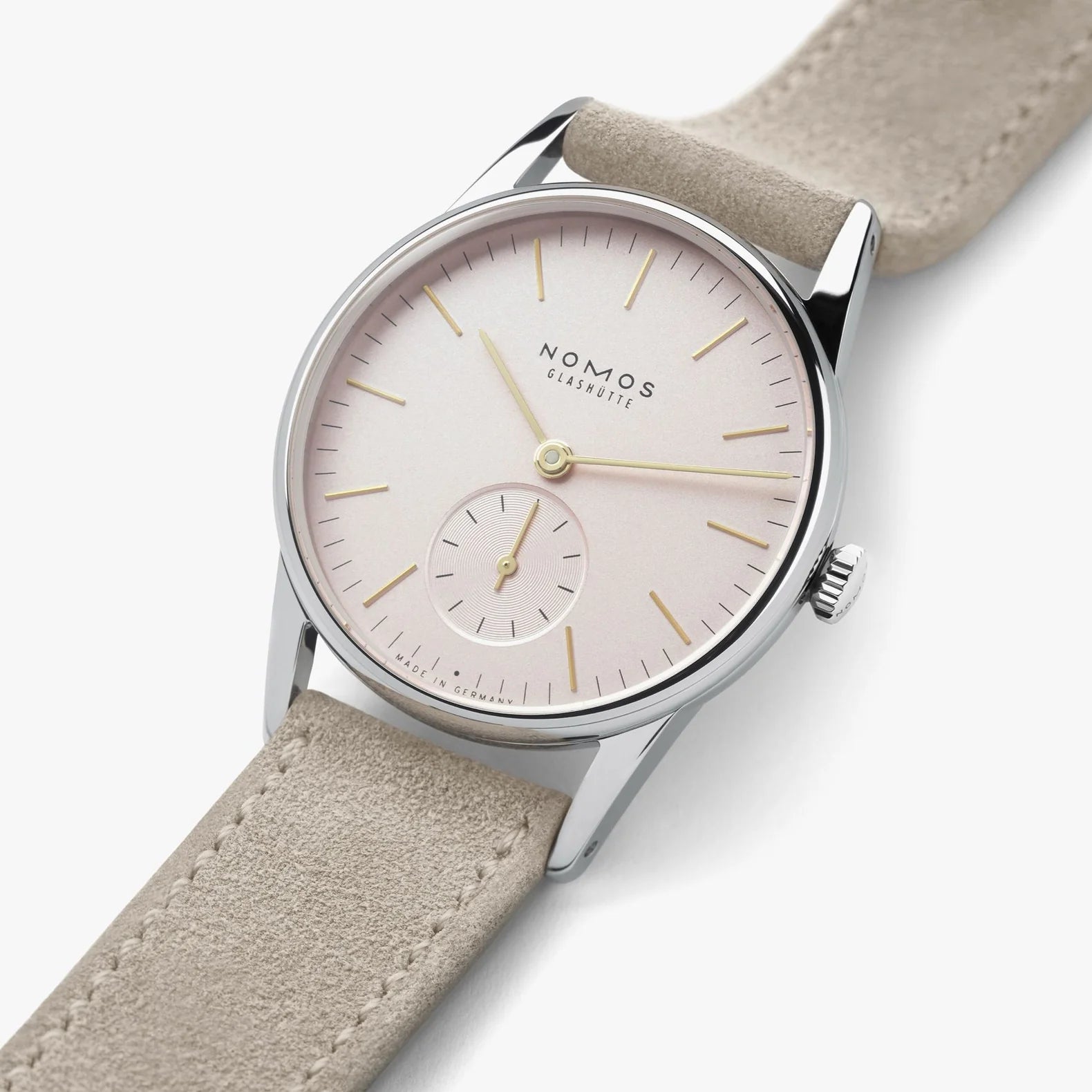 NOMOS Glashütte Orion 33mm watch with blush pink dial, stainless steel case, and light vegan velour strap on grey background, flat lay view.