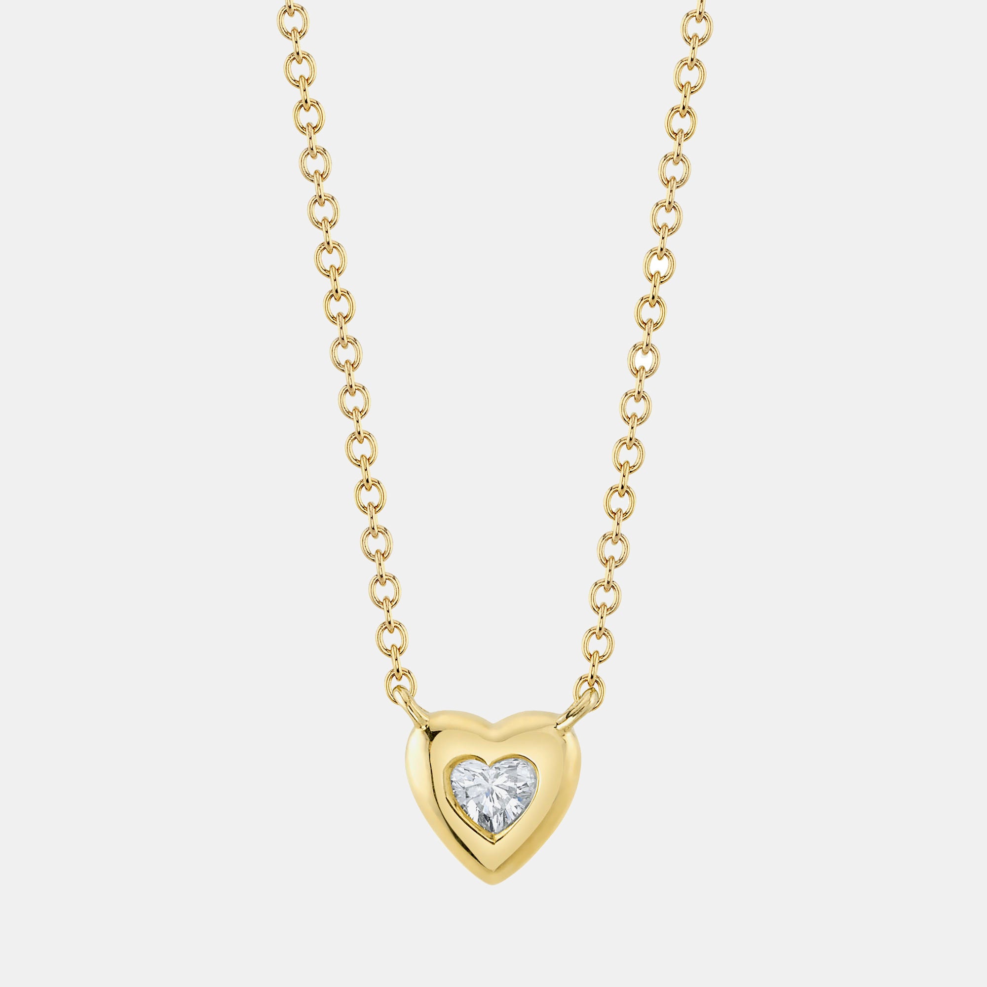 Yellow gold necklace with a heart-shaped bezel pendant featuring a round diamond