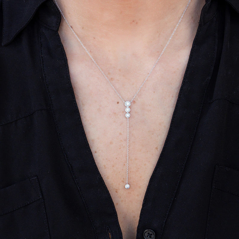 Women wearing white gold diamond halo lariat necklace.