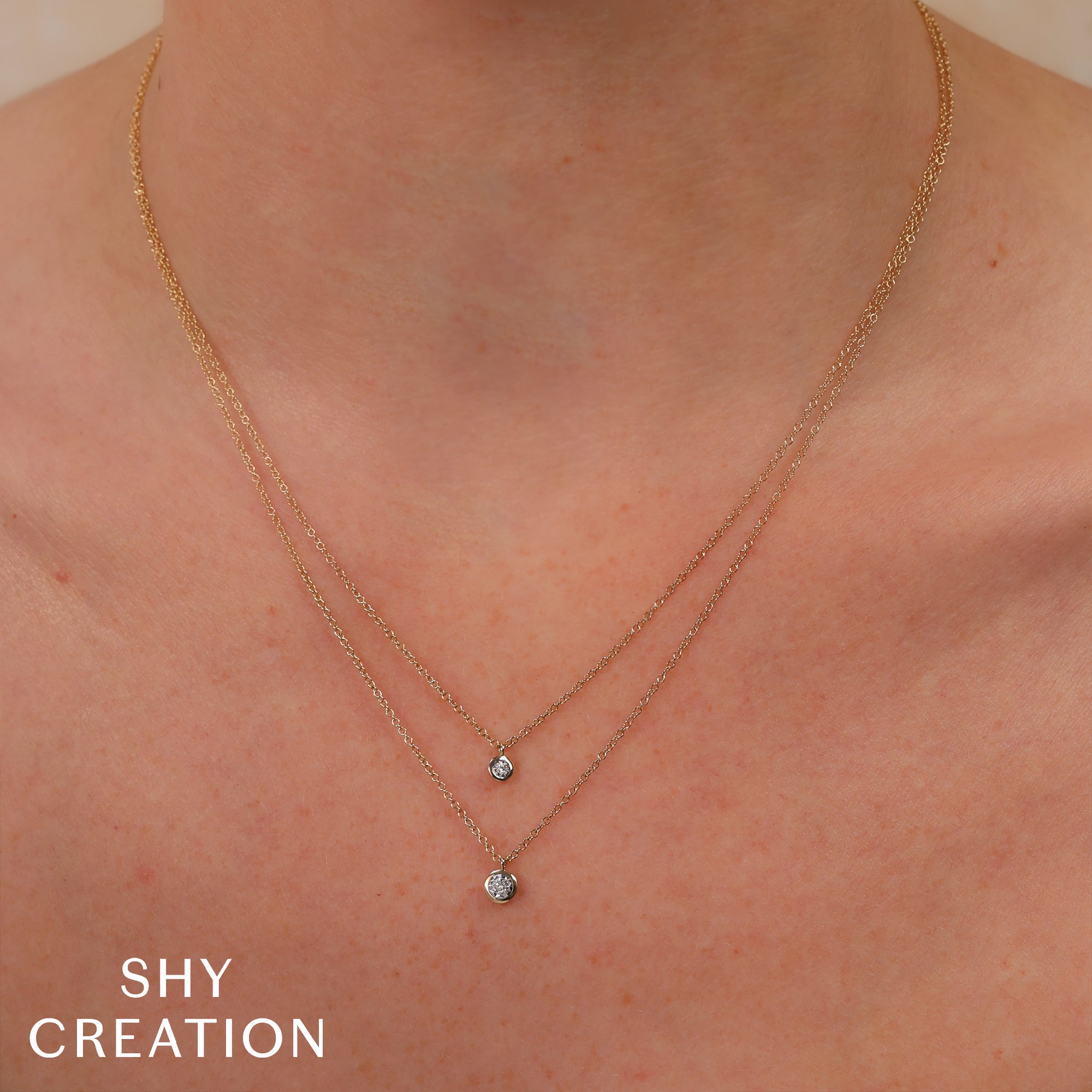 Gold necklace with small pendants on a person's neck.