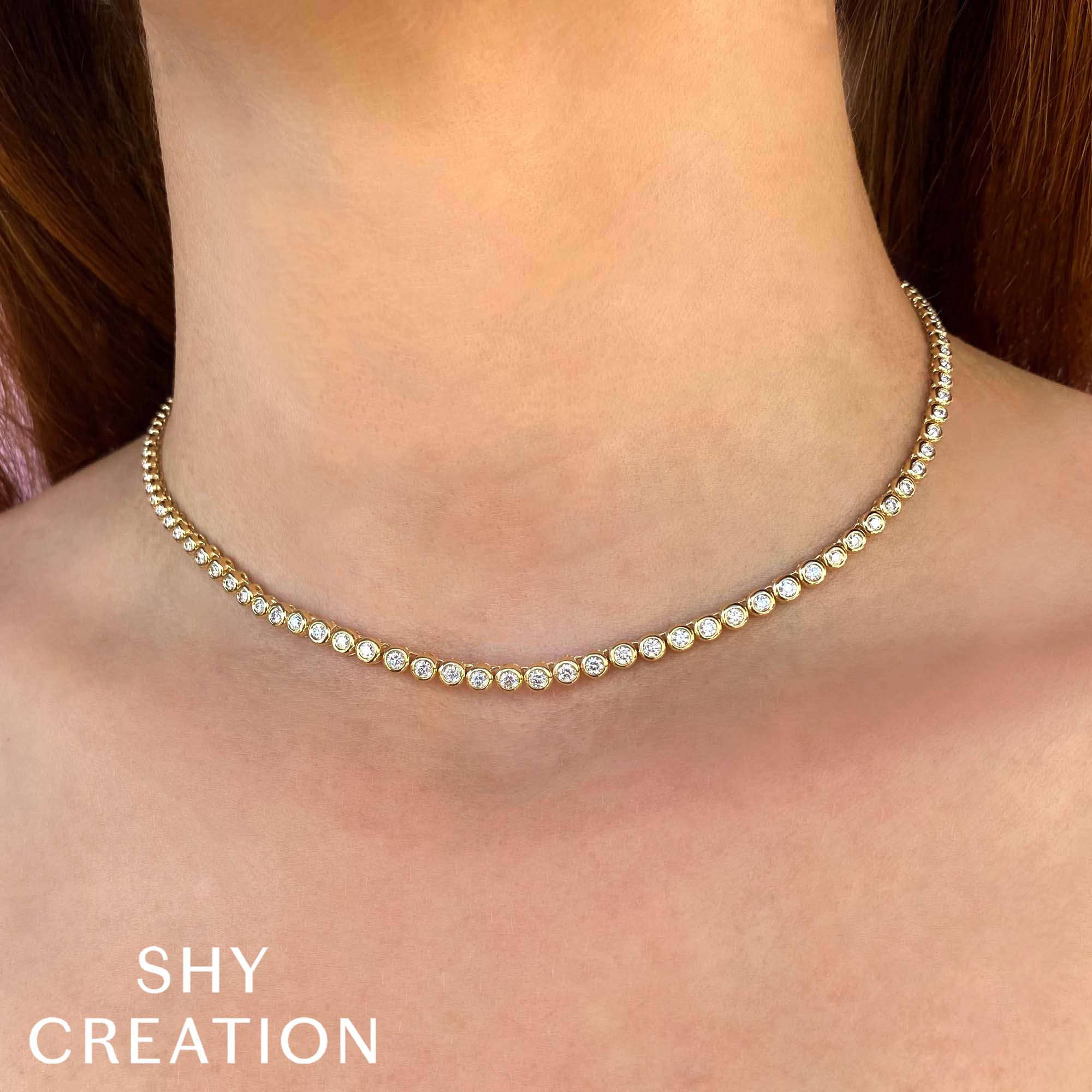 Woman wearing yellow gold diamond tennis necklace.