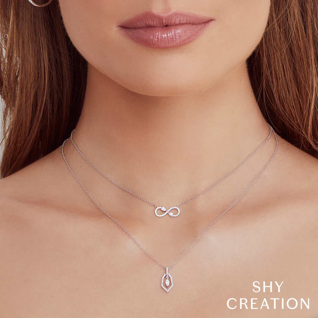 Woman wearing white Gold infinity pendant necklace with diamond accents