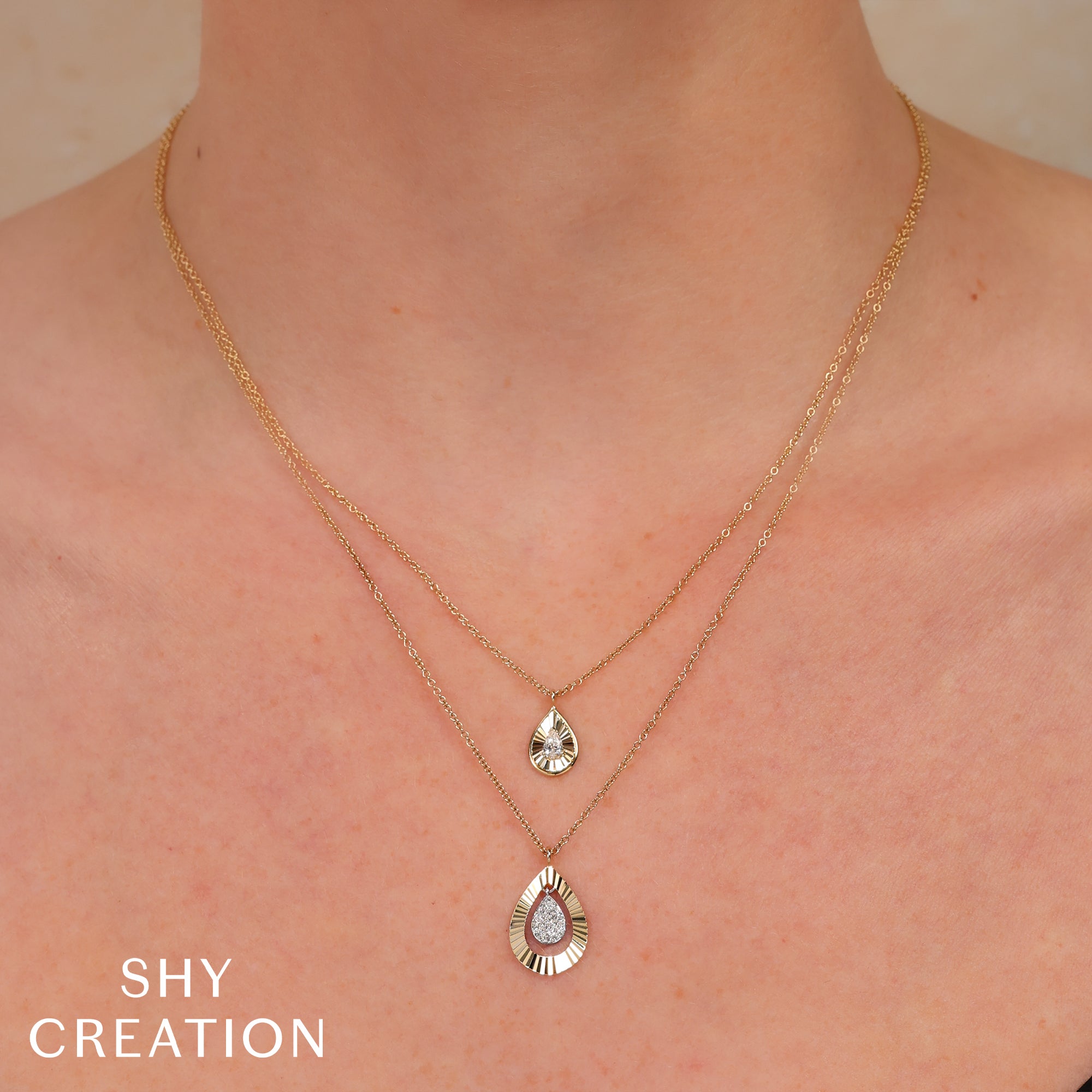 Woman wearing yellow gold pear diamond pendant necklace