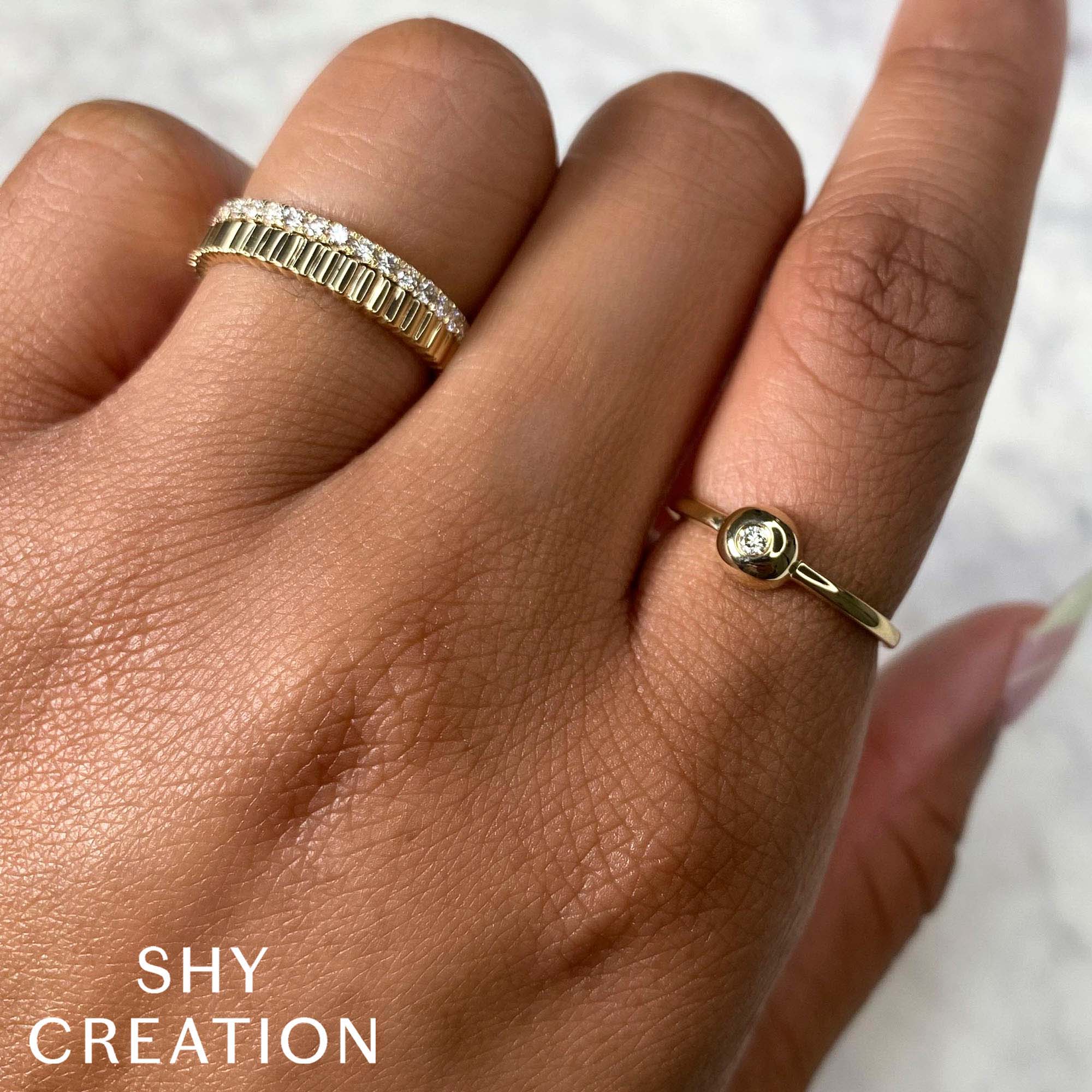 Woman's hand wearing yellow gold ribbed diamond fashion ring