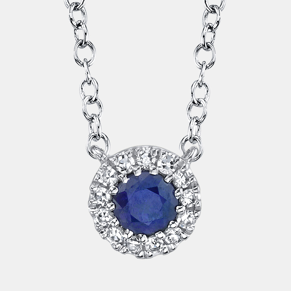 Silver necklace with a blue sapphire pendant on a white background