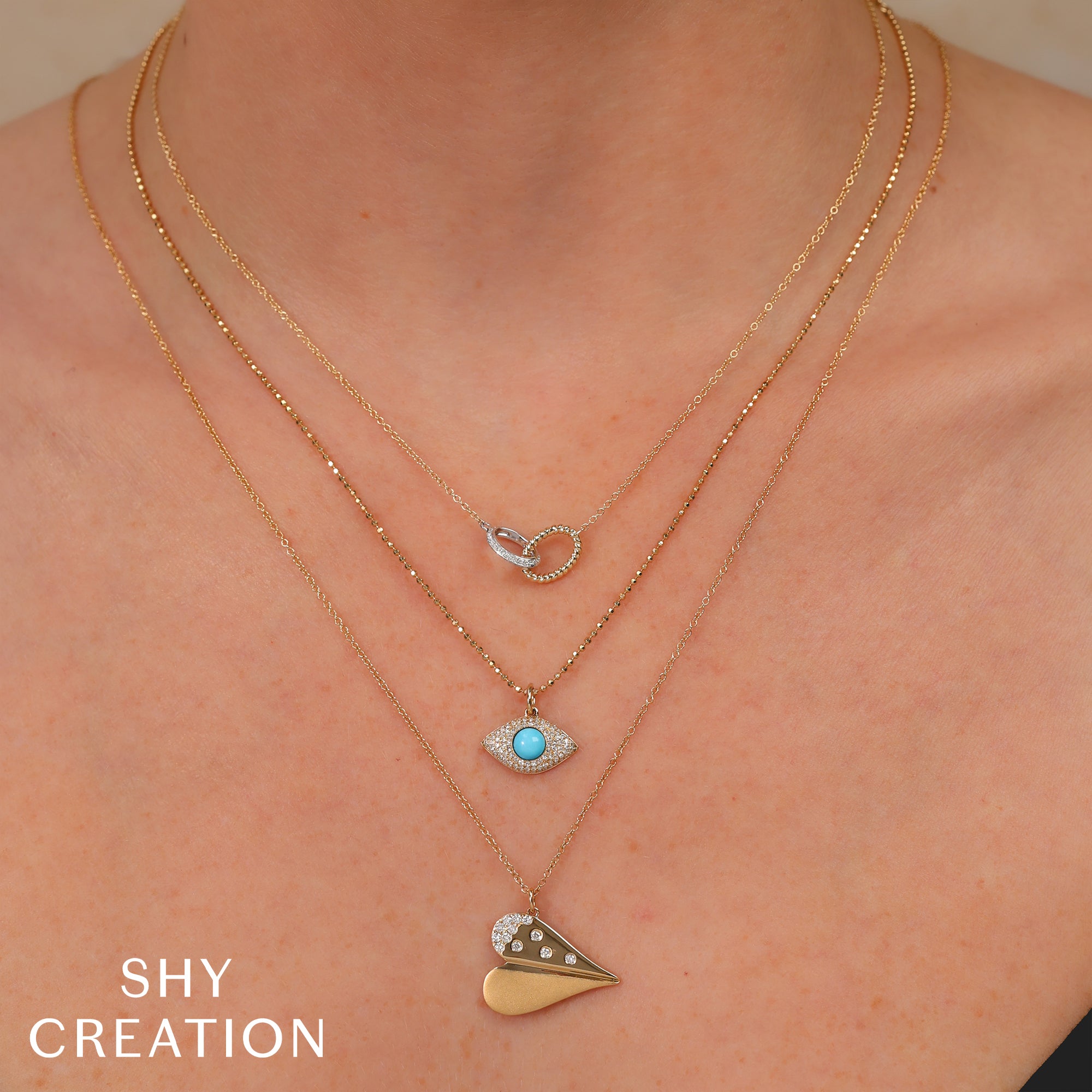 Woman wearing white and yellow gold interlocking circle pendant necklace.