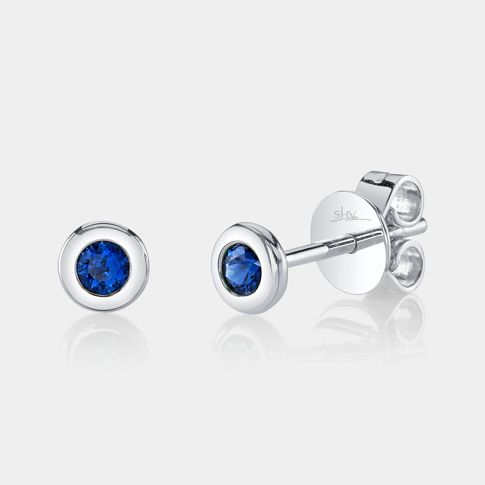 White gold bezel set sapphire stud earrings, front angle view