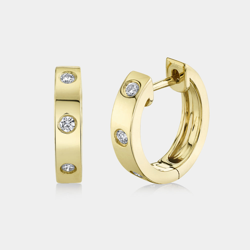 Yellow gold bezel set diamond huggie earrings, side angle view