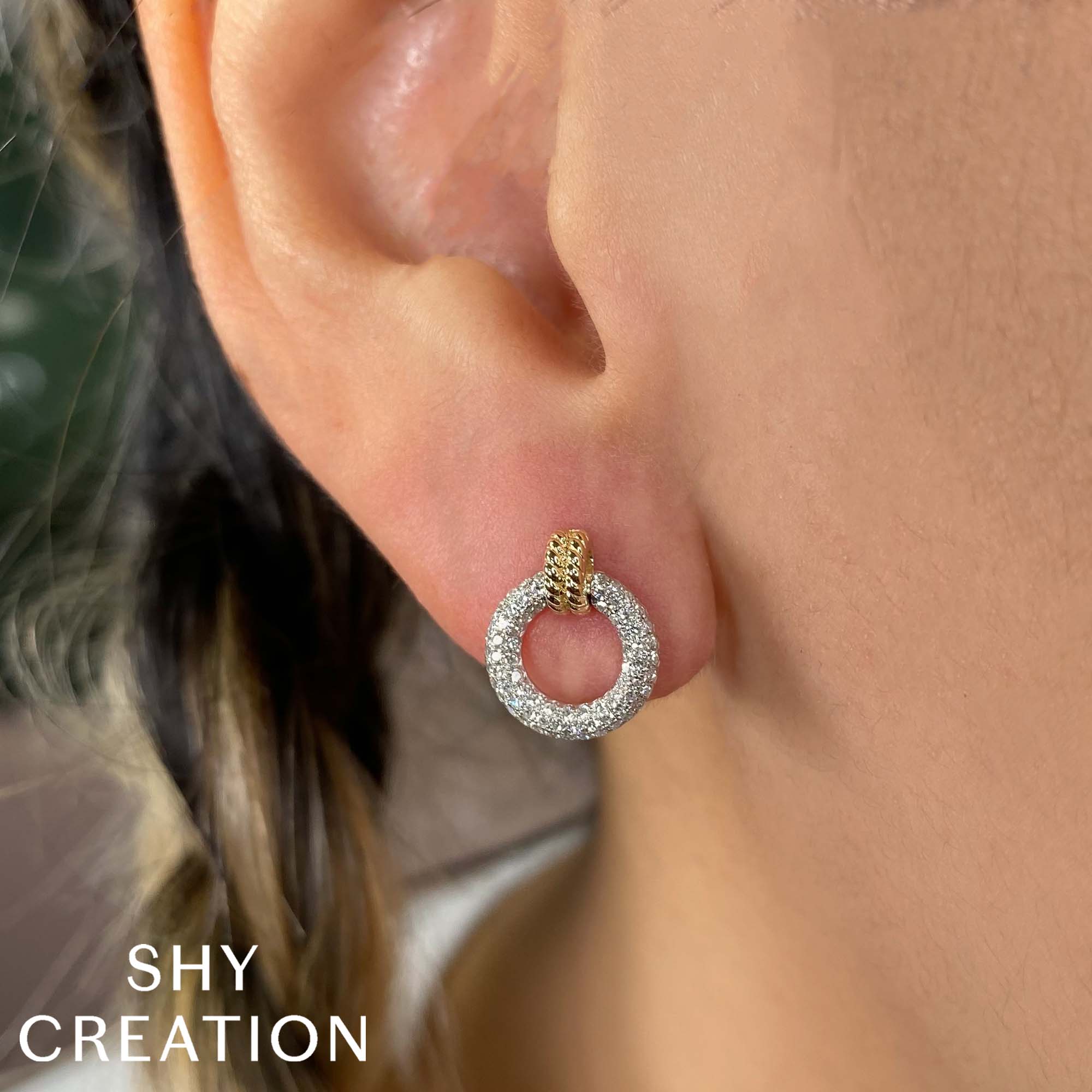 Woman wearing yellow gold diamond circle stud earrings