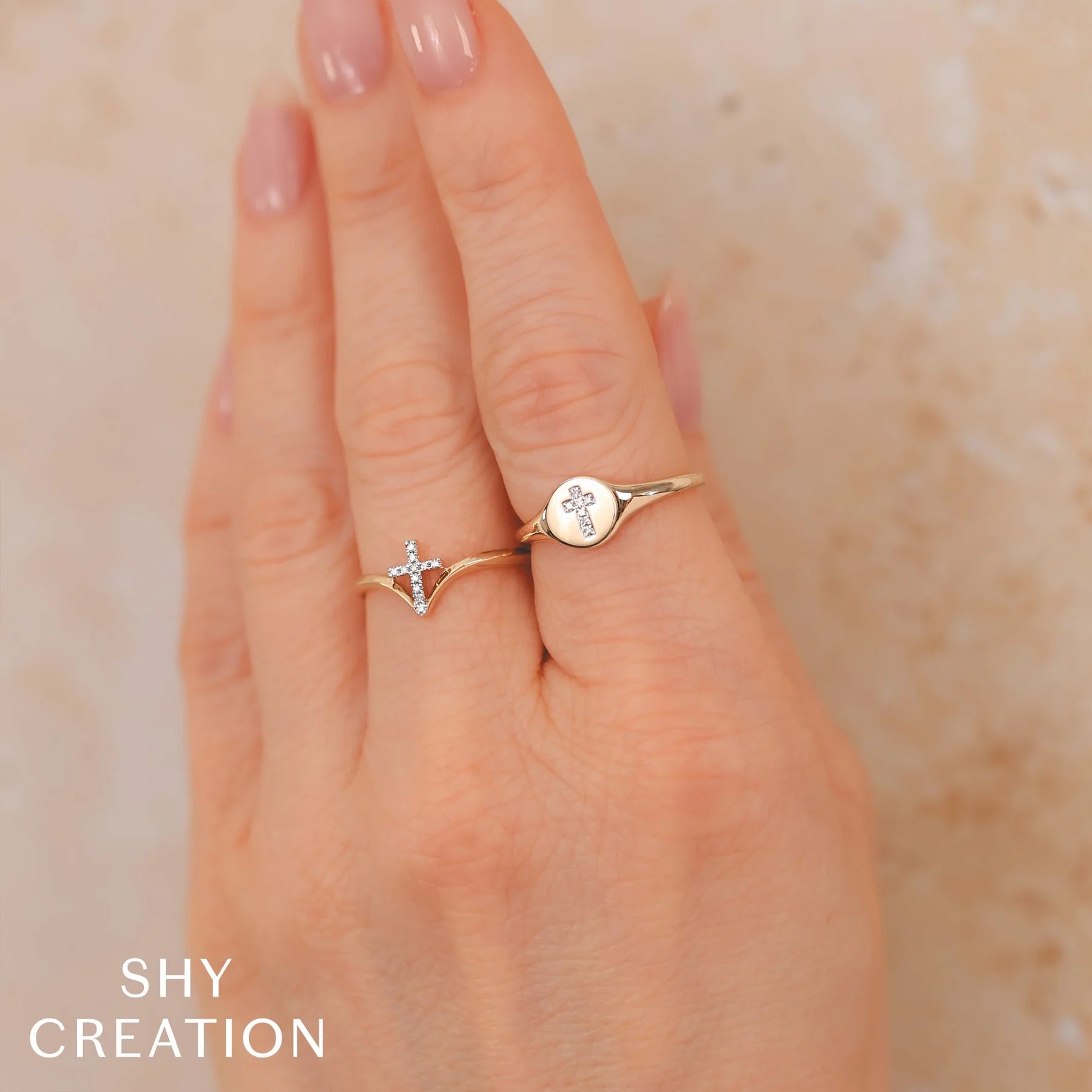 Woman's hand wearing a yellow gold diamond cross ring