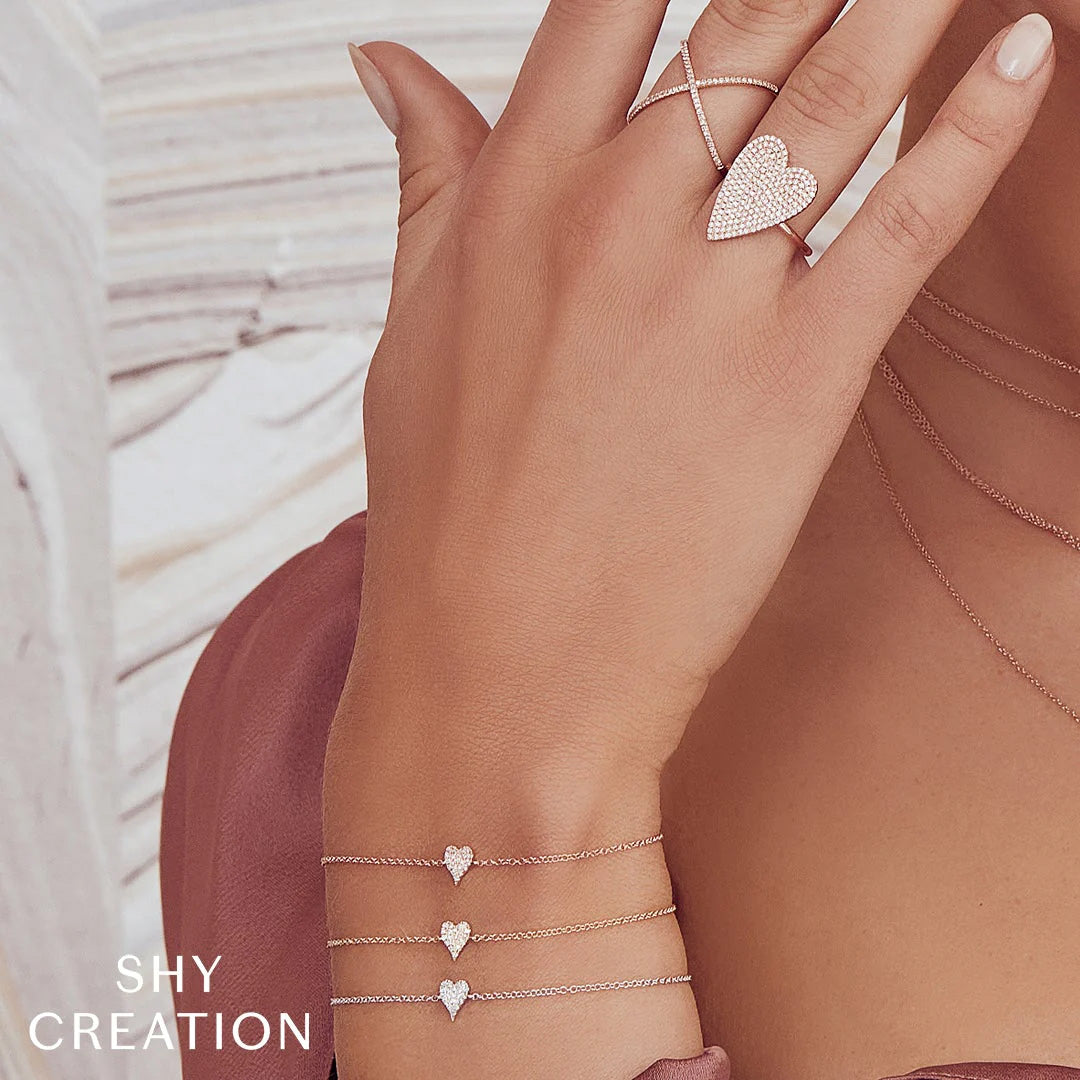 Woman wearing yellow gold pave diamond charm bracelet