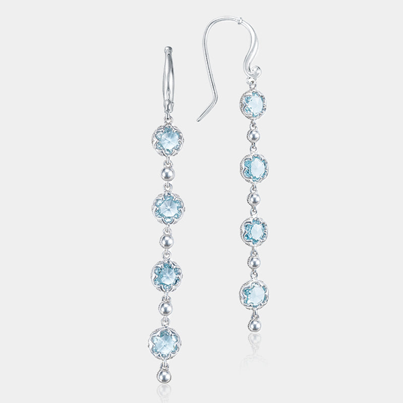 Sterling Silver and Gold Blue Topaz Dangle Earrings on grey background.