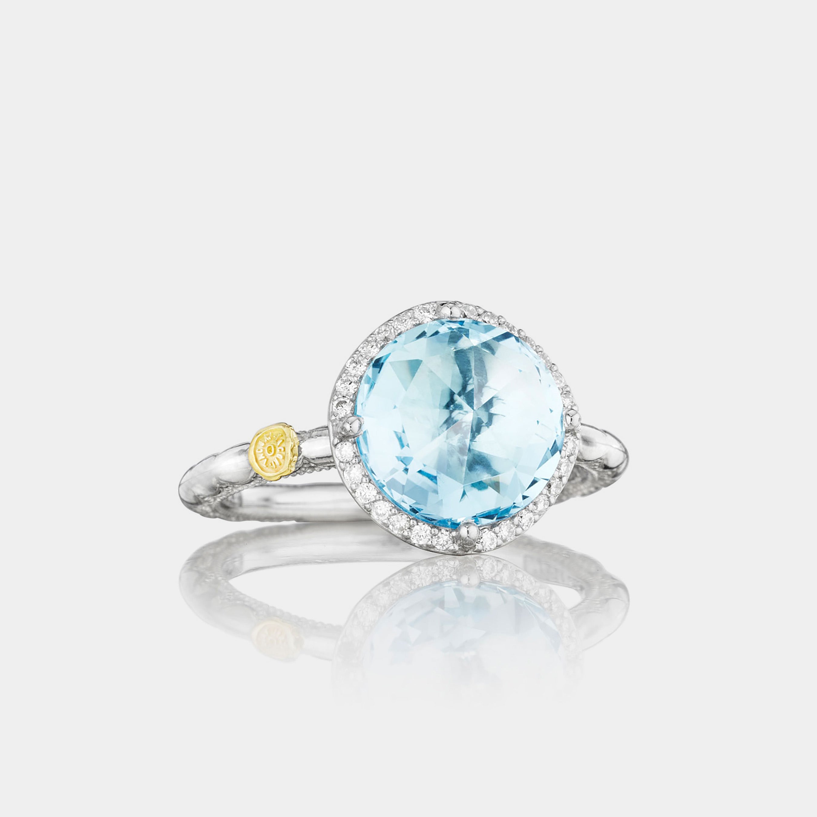 Sterling Silver and White Gold Round Blue Topaz and Diamond Ring on grey background.