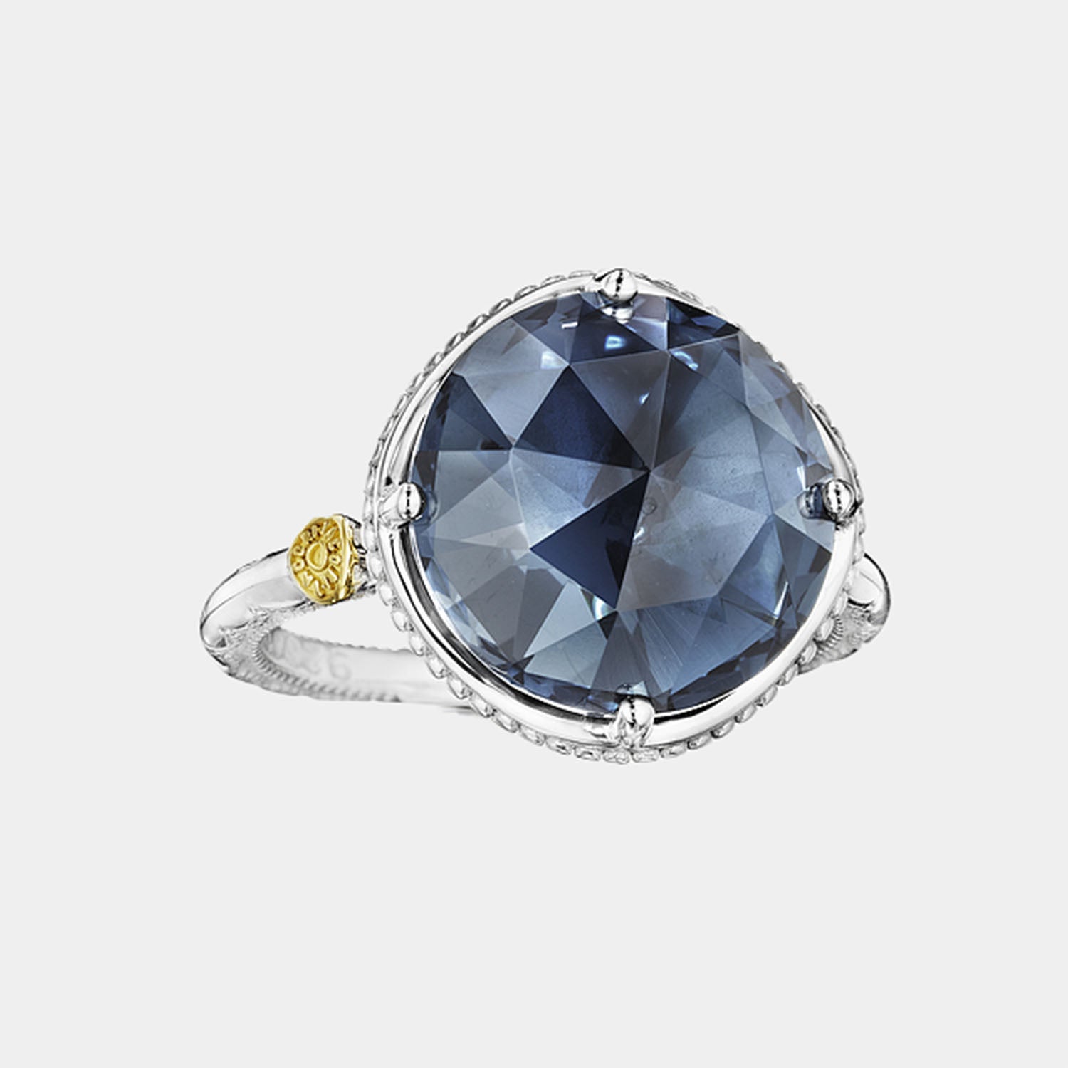 Sterling Silver and Yellow Gold Round Blue Topaz Ring on grey background.