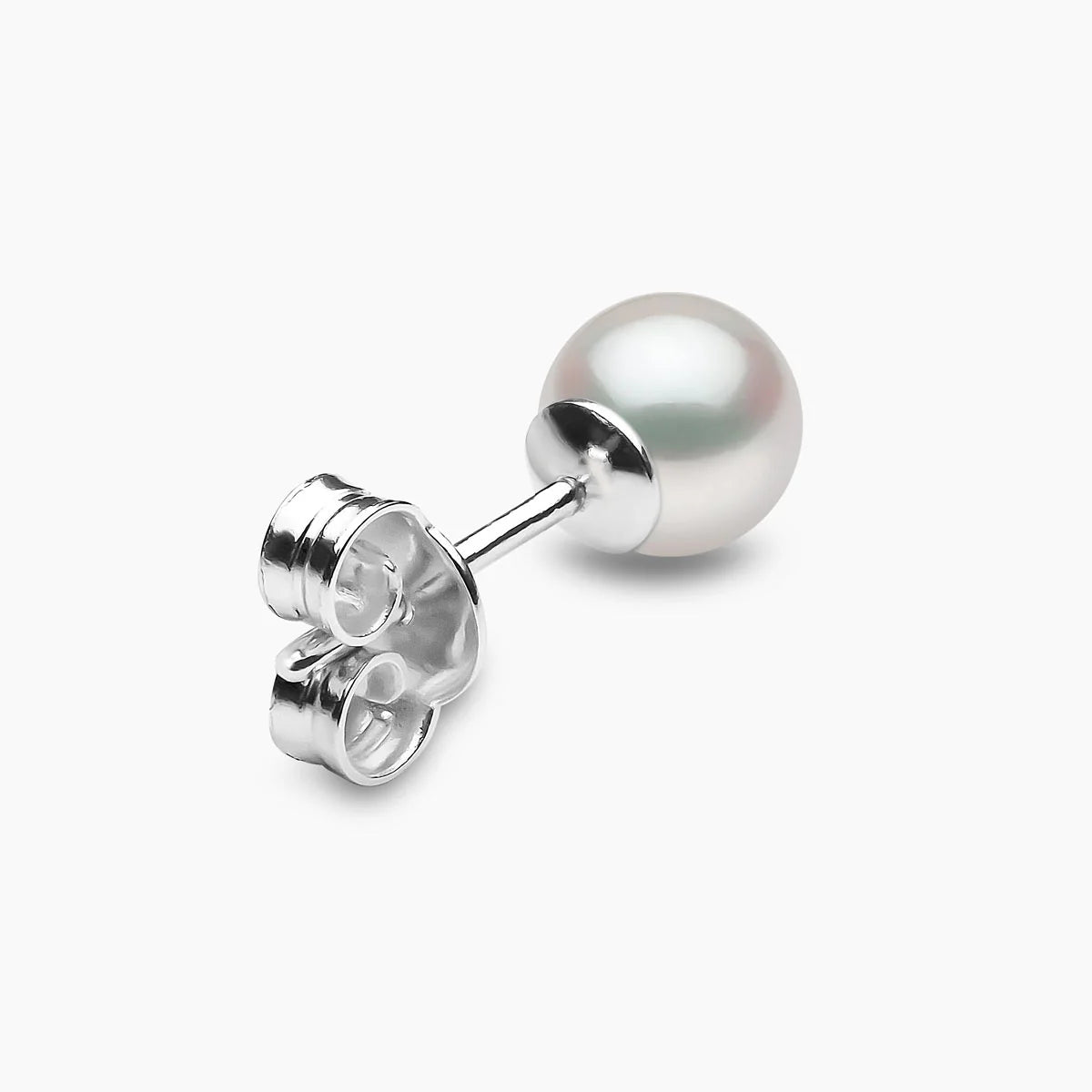 Single pearl stud earring on a light gray background