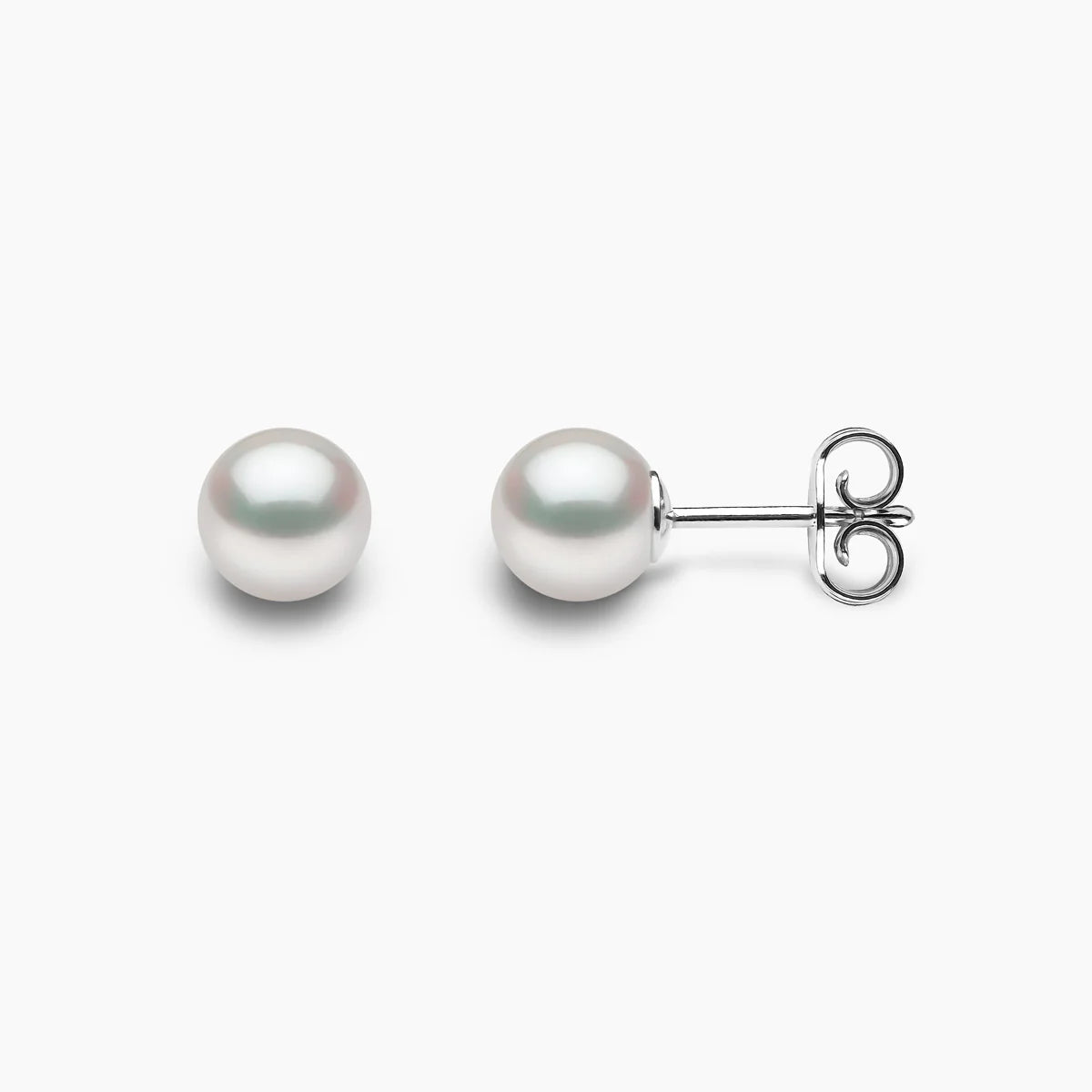 Pair of pearl stud earrings on a light gray background, side and front view