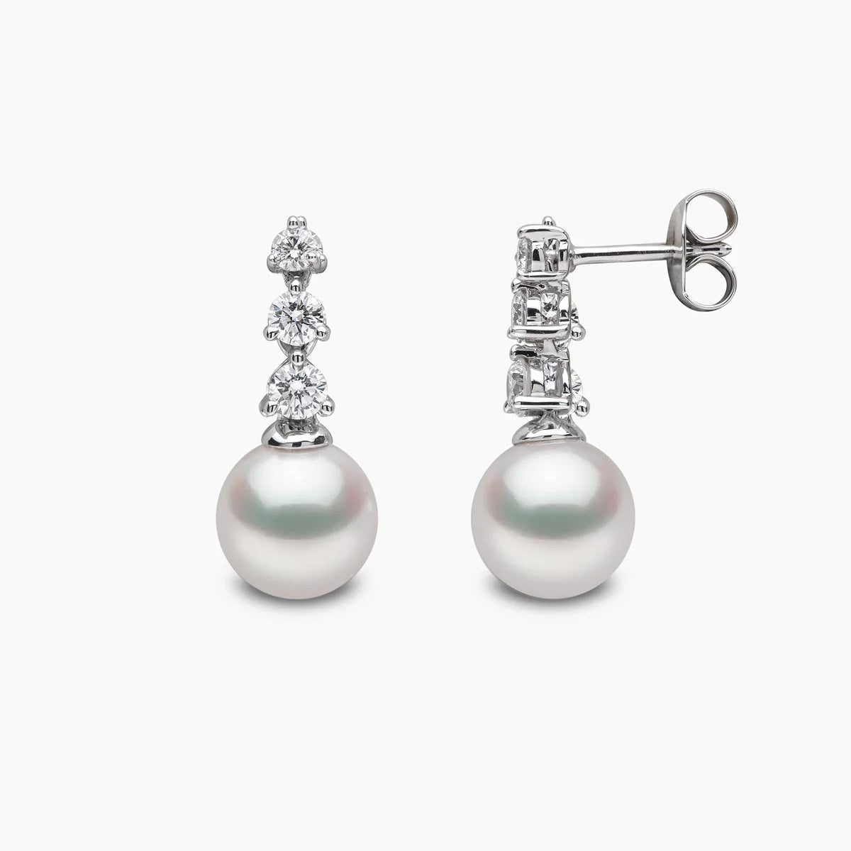 White gold pearl and diamond drop earrings on grey background, front and side view