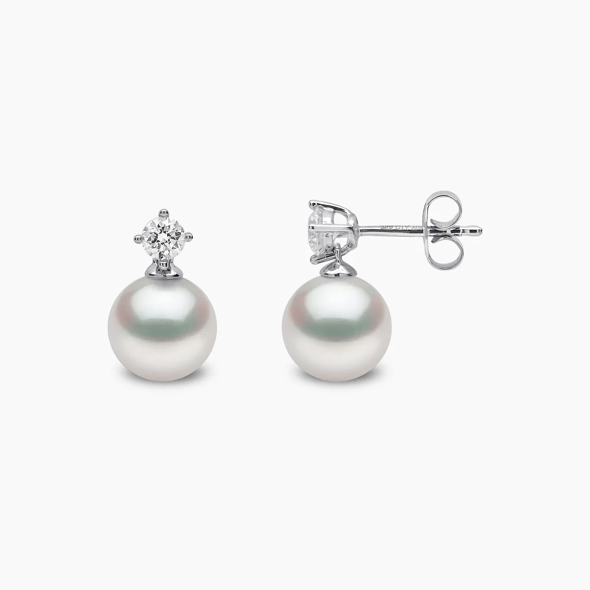 White gold pearl and diamond drop earrings on grey background, front and side view