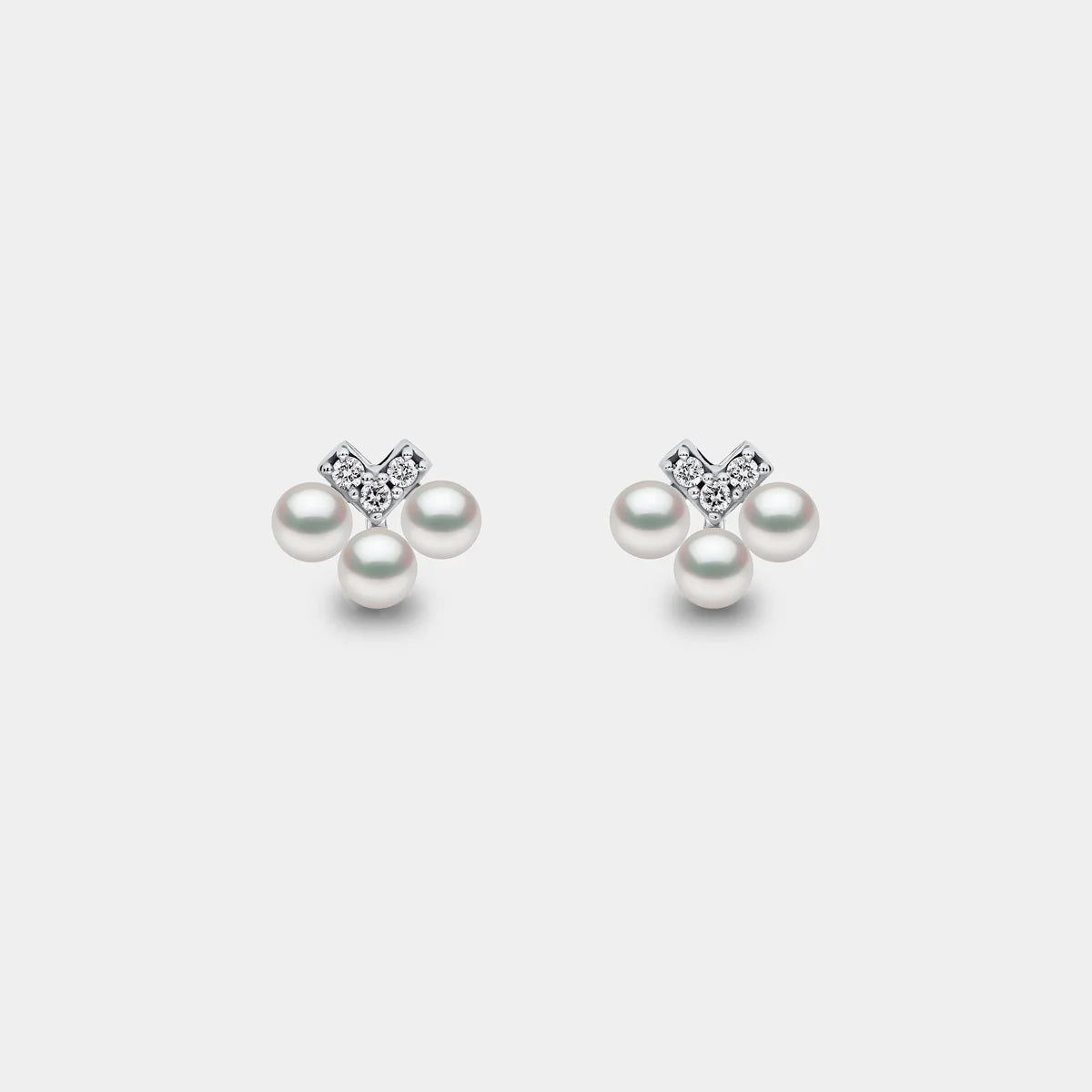 White gold pearl and diamond v drop earrings on grey background, front view
