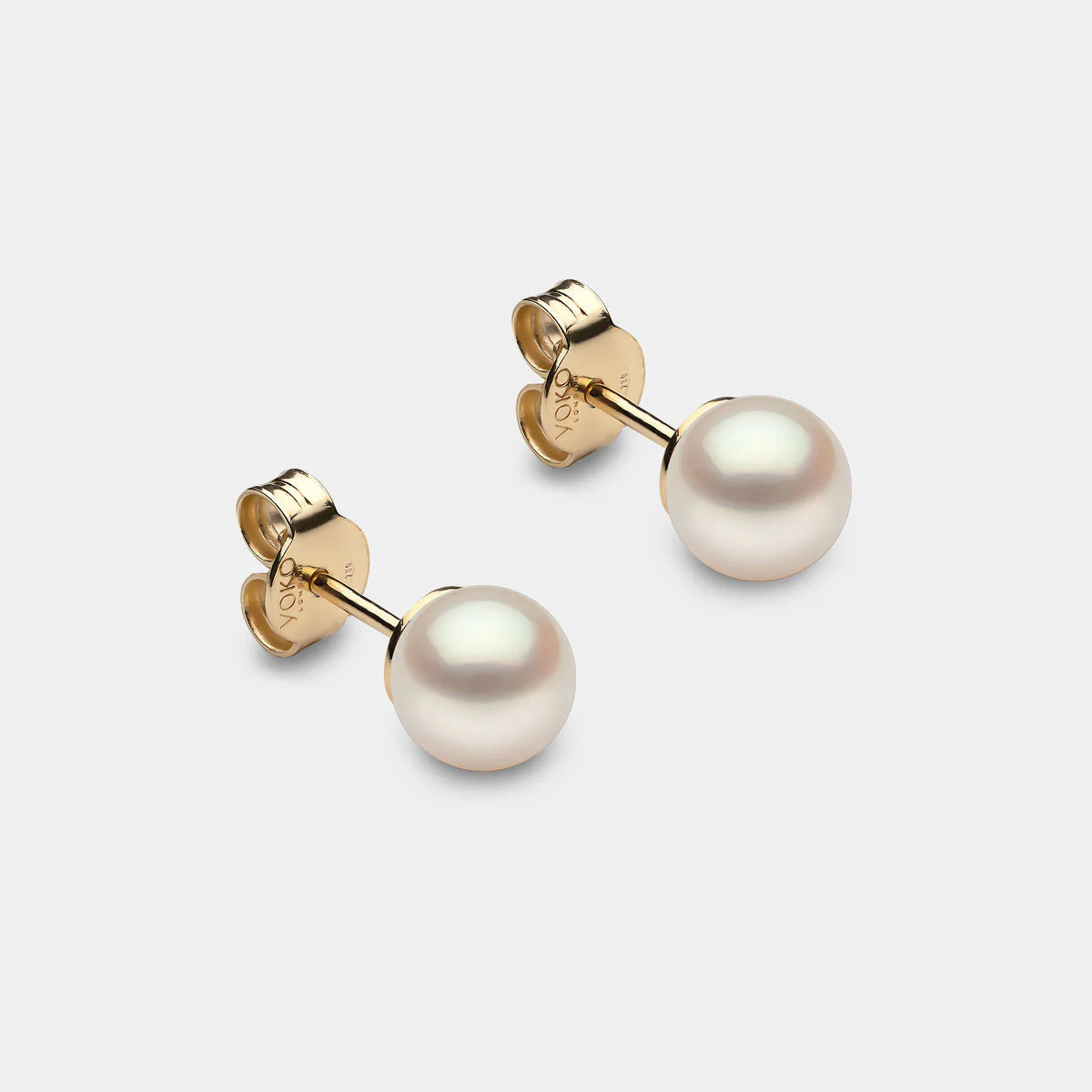 Classic pearl stud earrings in yellow gold, side angle view